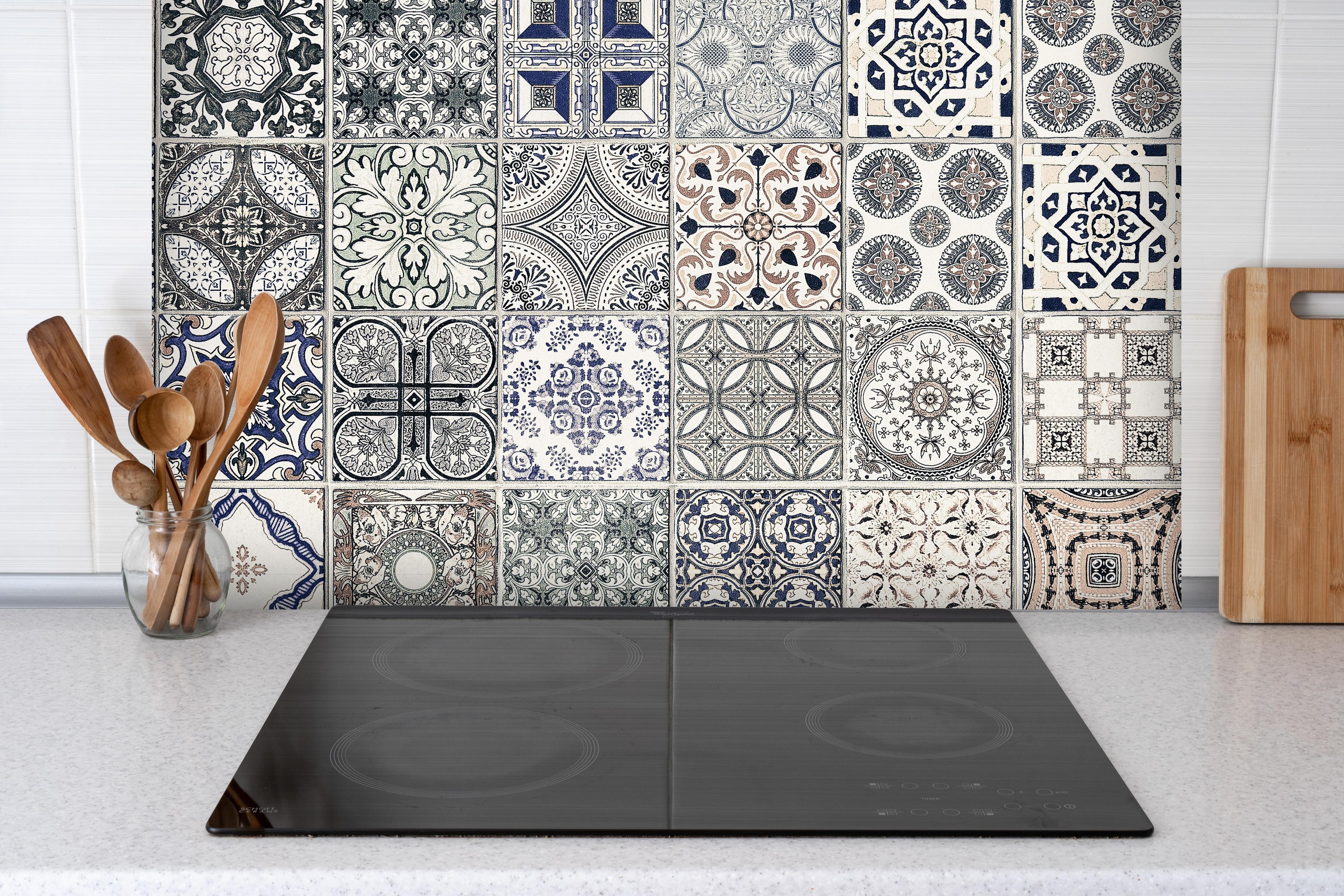 Spritzschutz - Keramik-Patchwork im arabischen Stil hinter einem Cerankochfeld zwischen Holz-Kochutensilien