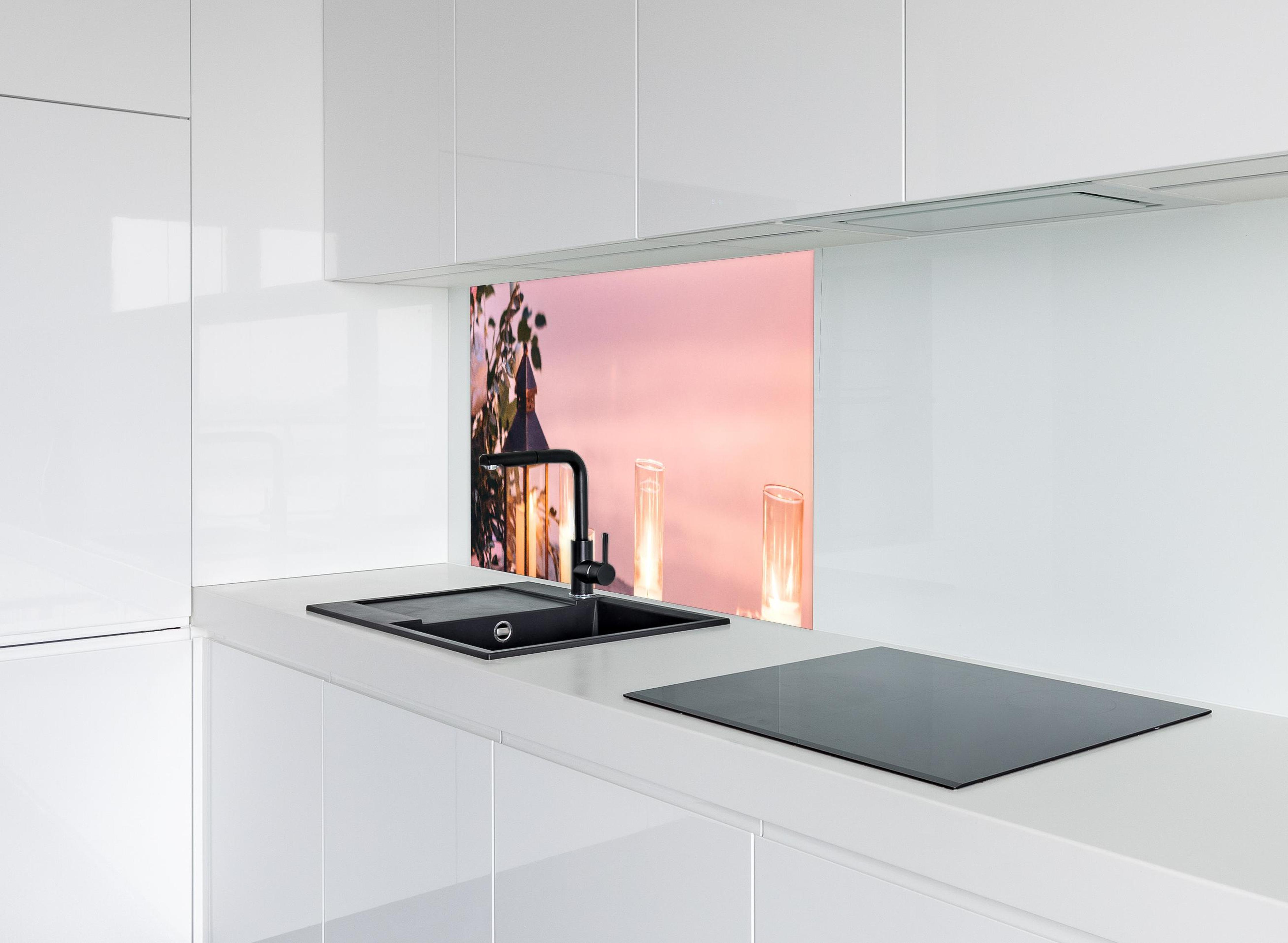 Spritzschutz - Kerzen und Blumen auf Steinmauer hinter modernem schwarz-matten Spülbecken in weißer Hochglanz-Küche