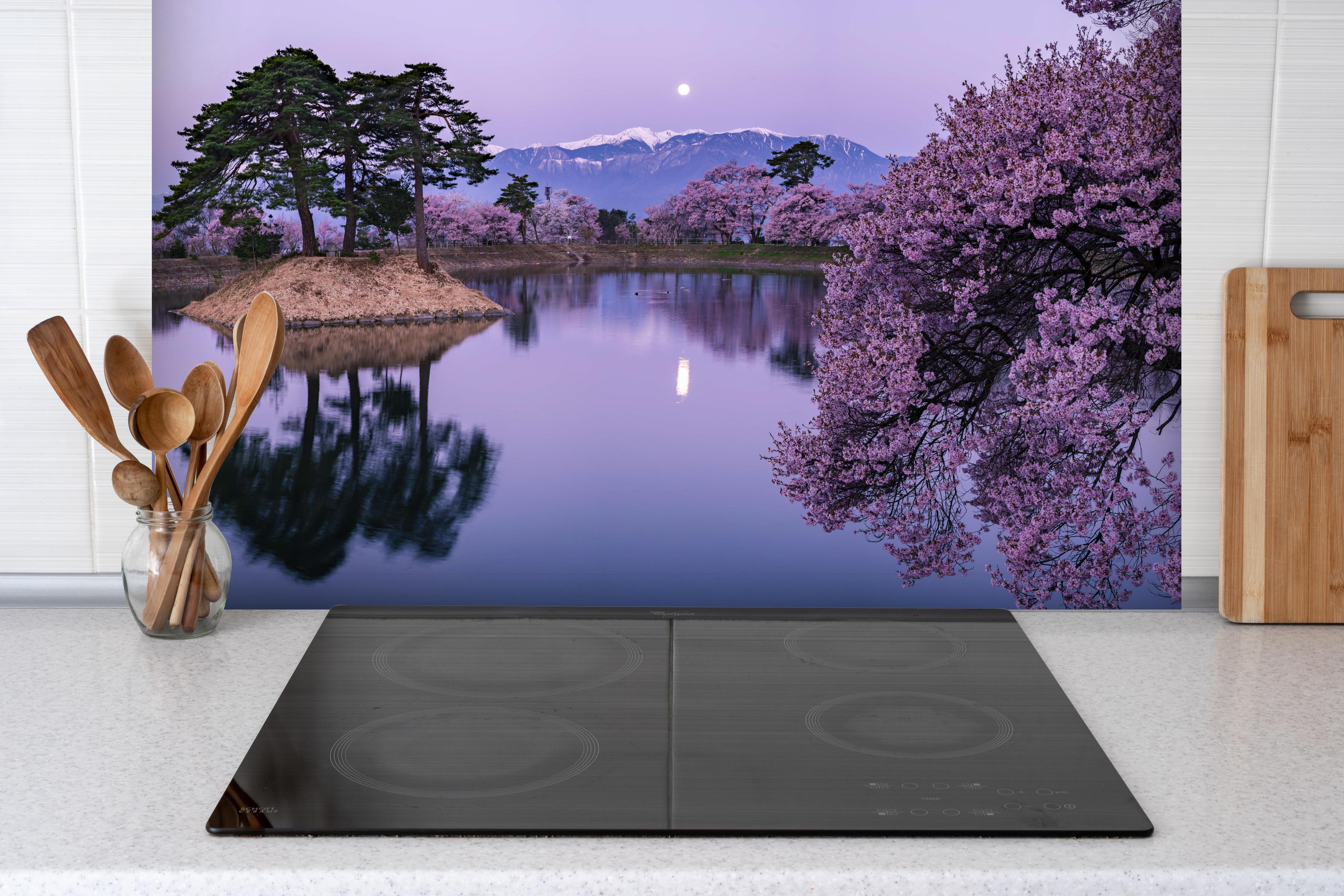 Spritzschutz - Kirschblüte - Vollmond hinter einem Cerankochfeld zwischen Holz-Kochutensilien