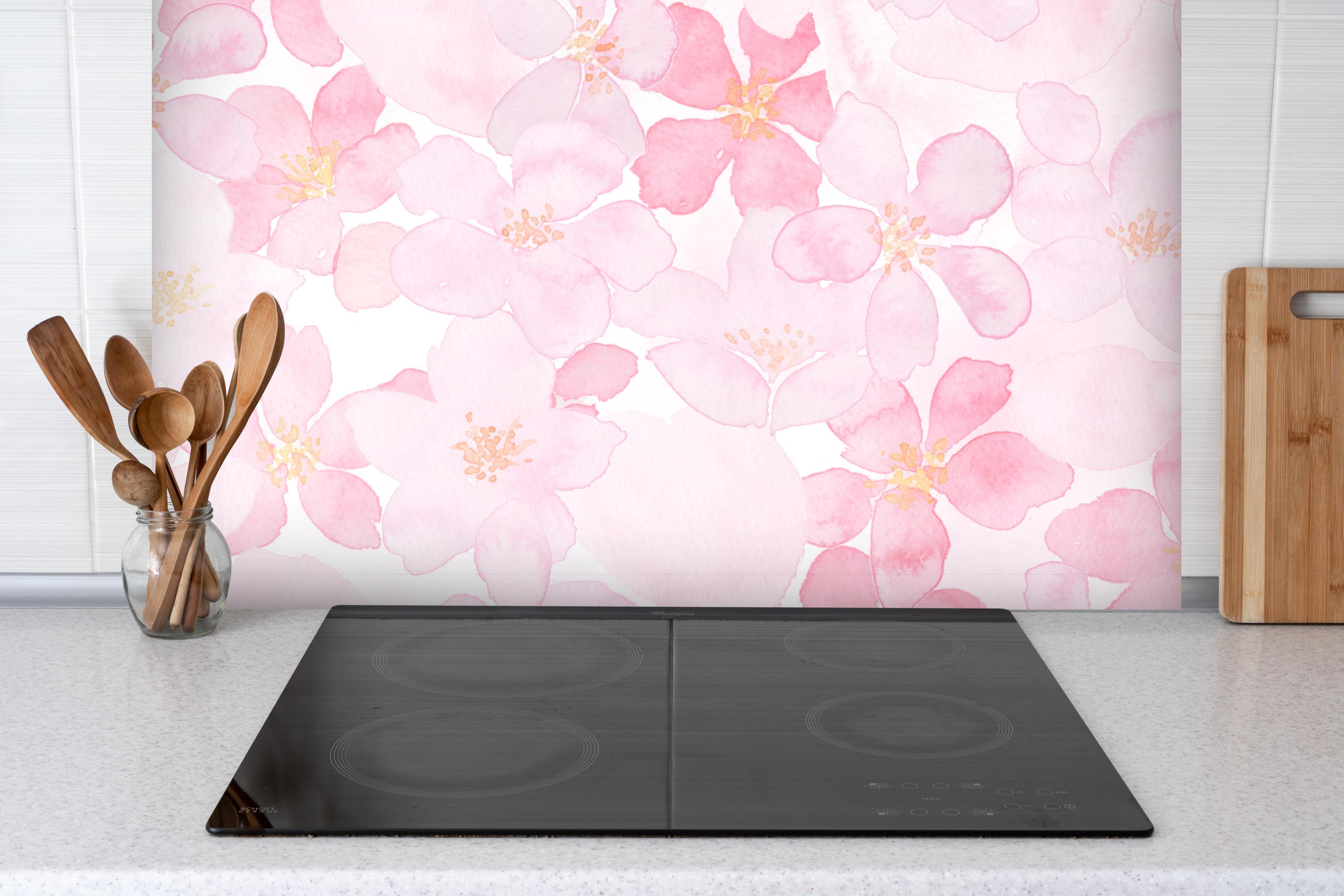 Spritzschutz - Kirschblüten auf weißem Hintergrund hinter einem Cerankochfeld zwischen Holz-Kochutensilien