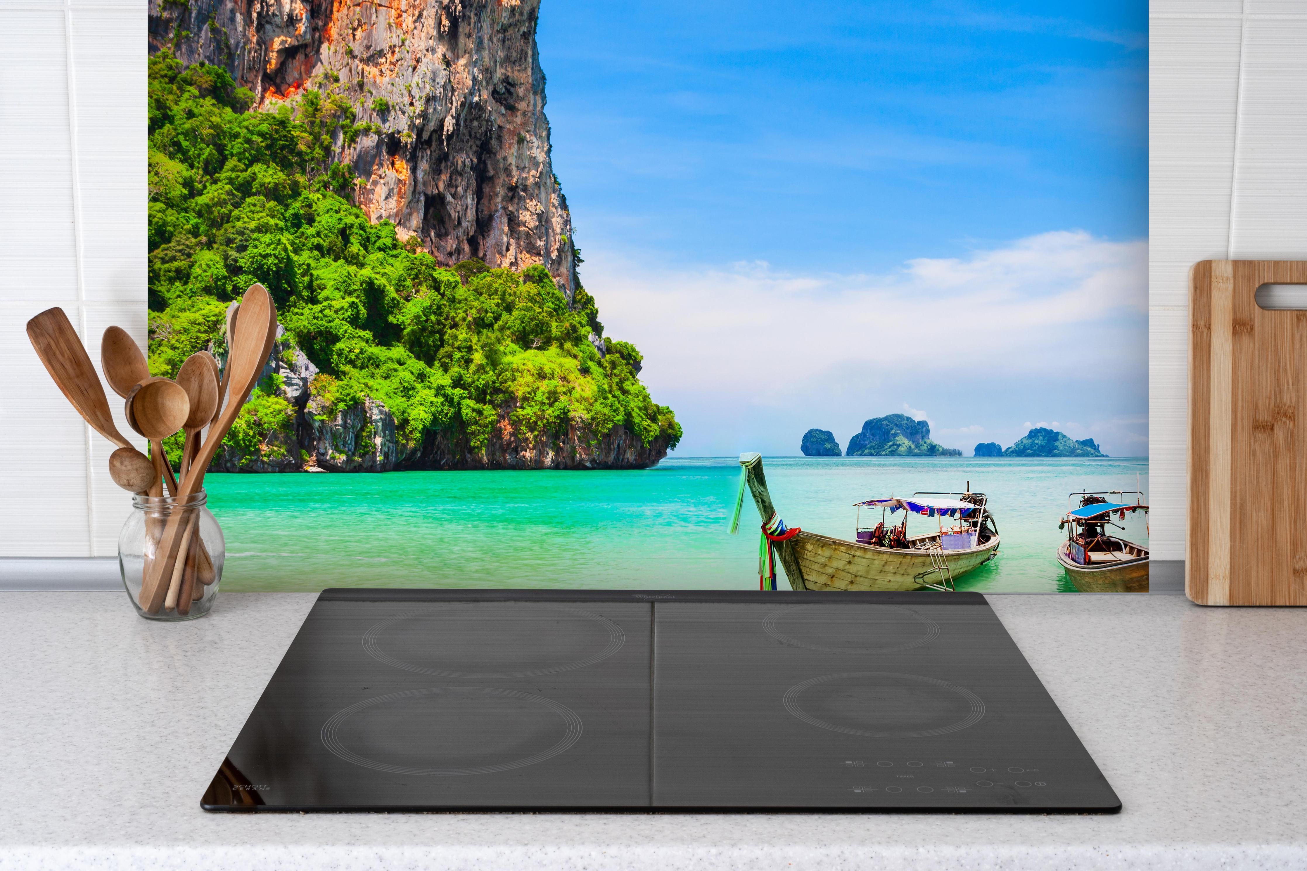 Spritzschutz - Klarwasserstrand in Thailand hinter einem Cerankochfeld zwischen Holz-Kochutensilien