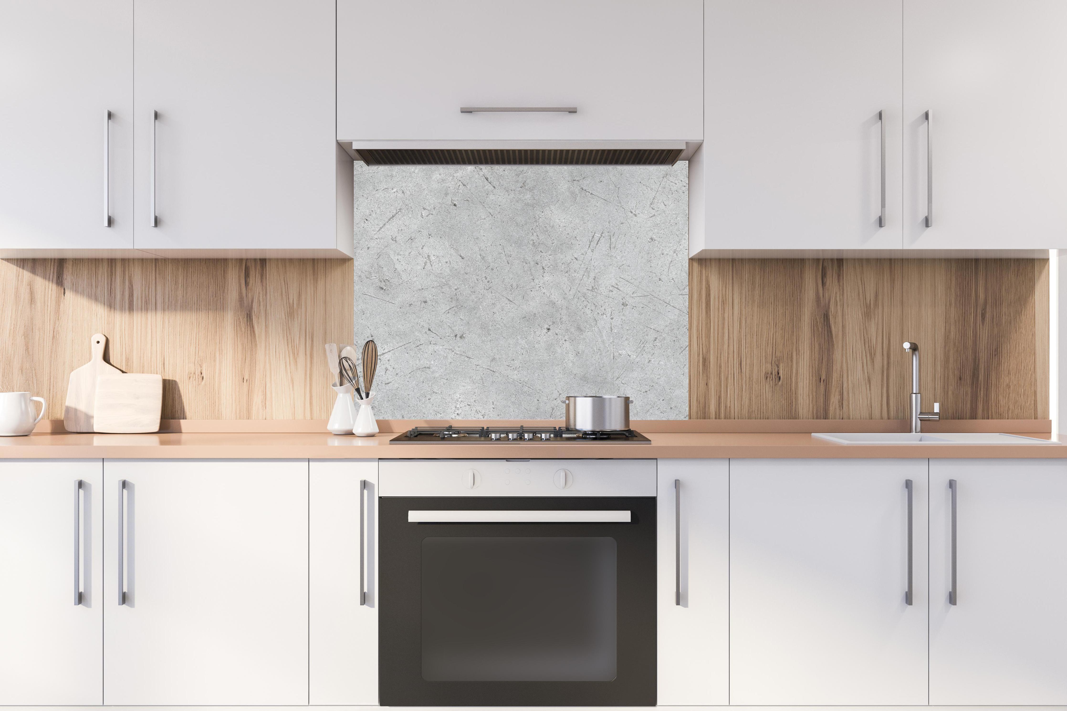 Spritzschutz - Kratzige graue Betonwand hinter stilvollem Gasherd unter Dunstabzugshaube