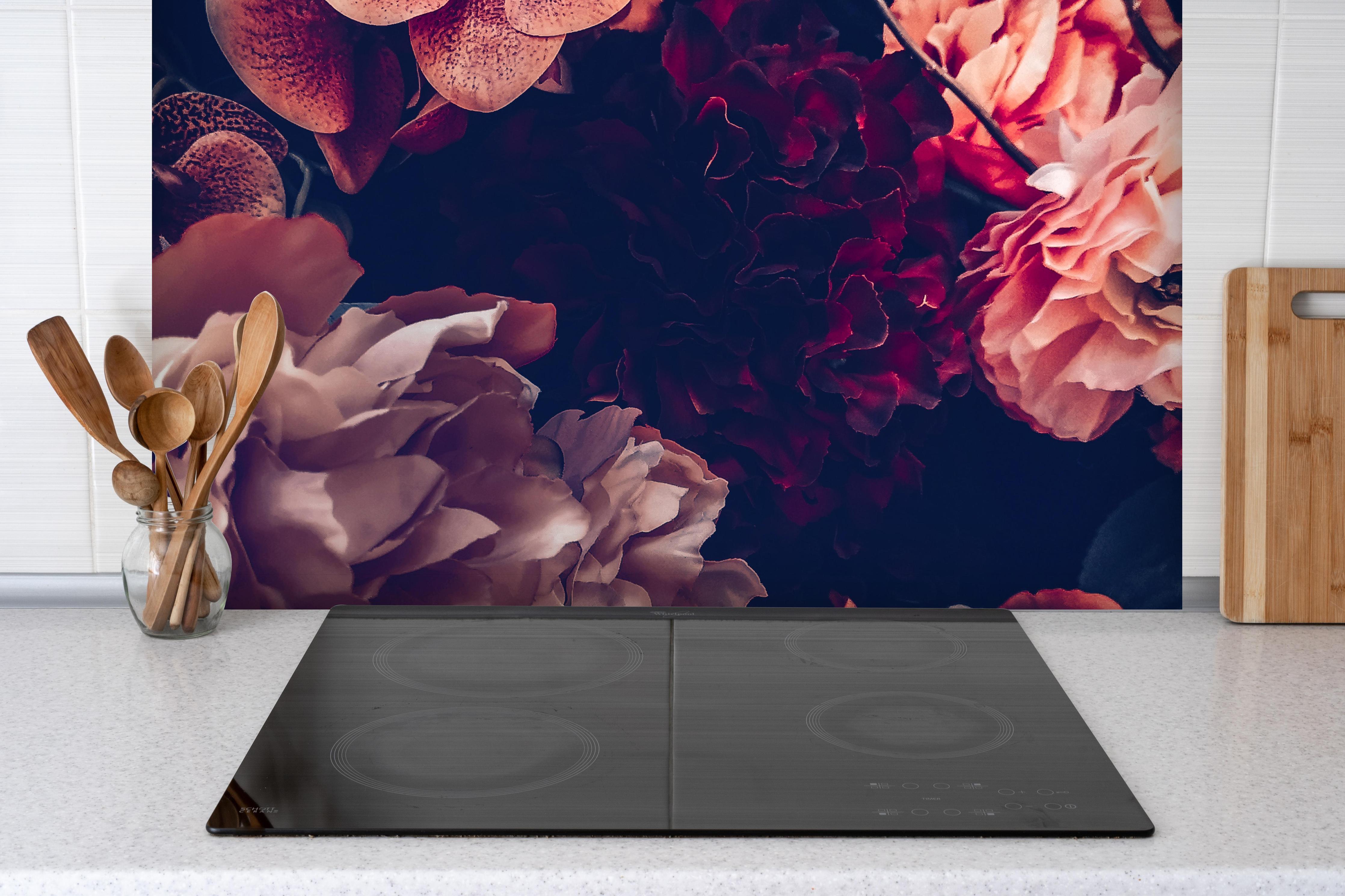 Spritzschutz - Künstliche Blumen im Vintage-Stil hinter einem Cerankochfeld zwischen Holz-Kochutensilien