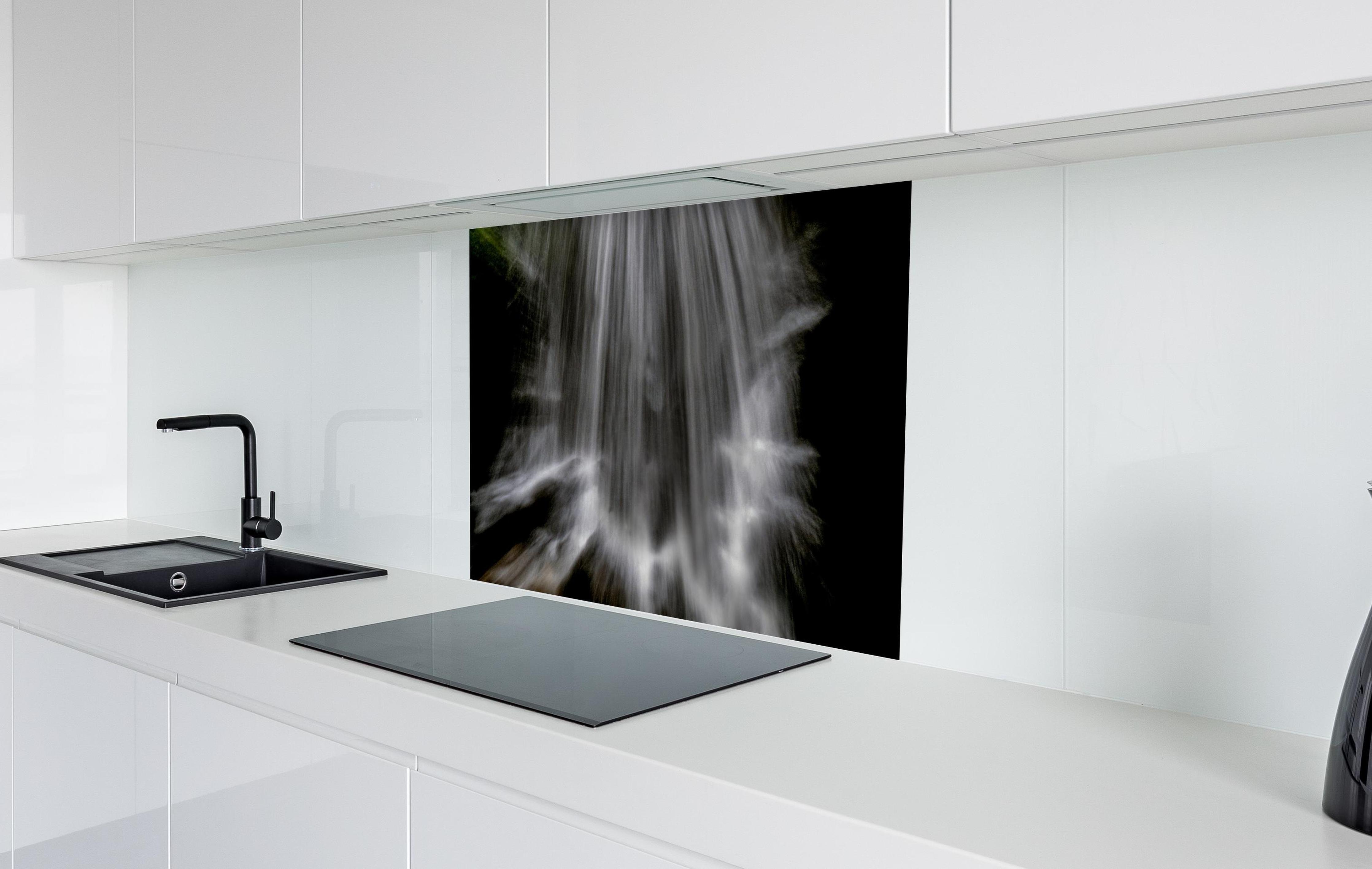 Spritzschutz - Kunstvoller Wasserfall in weißer Hochglanz-Küche hinter einem Cerankochfeld