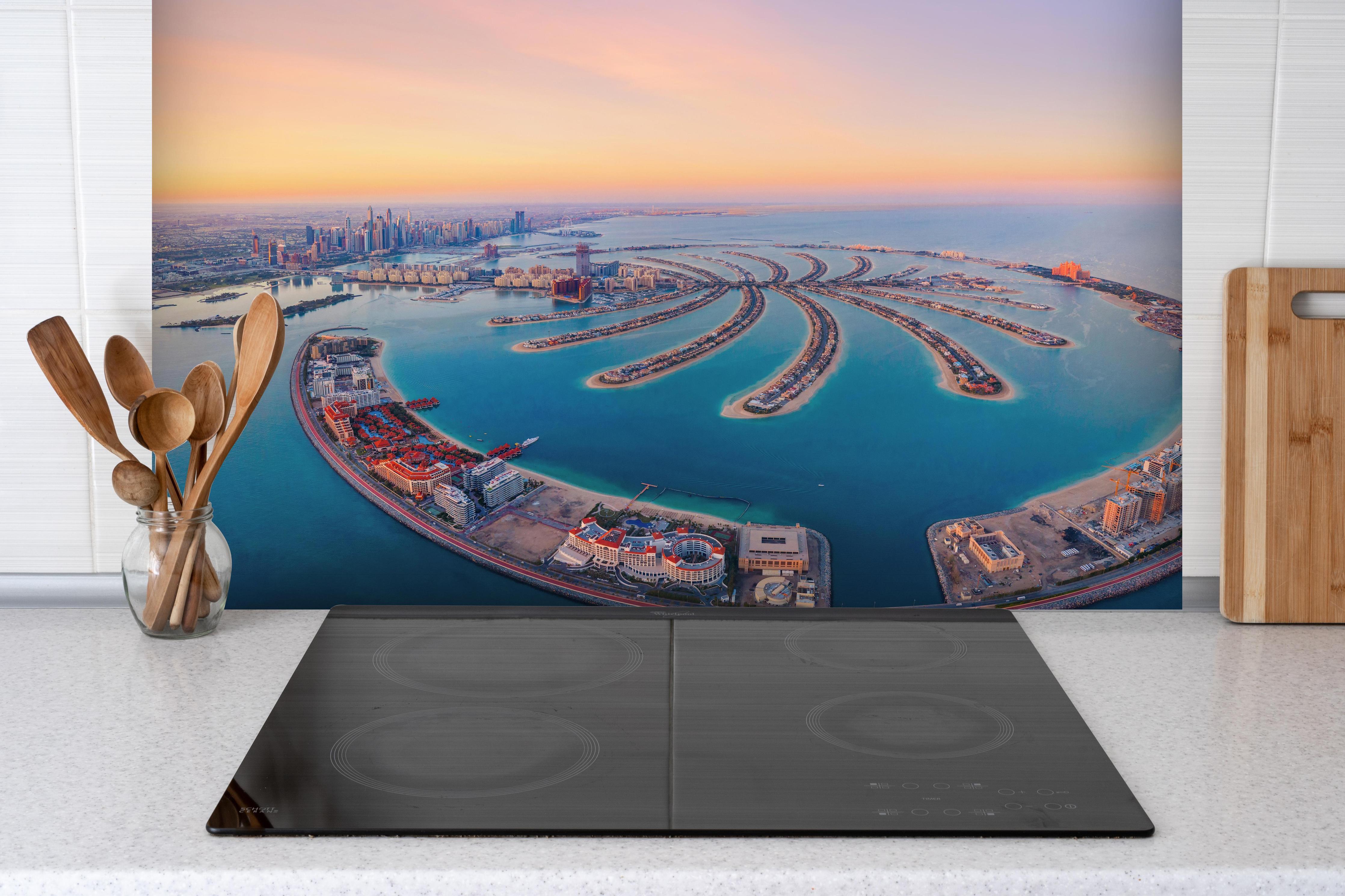 Spritzschutz - Luftaufnahme von Palm Jumeirah hinter einem Cerankochfeld zwischen Holz-Kochutensilien