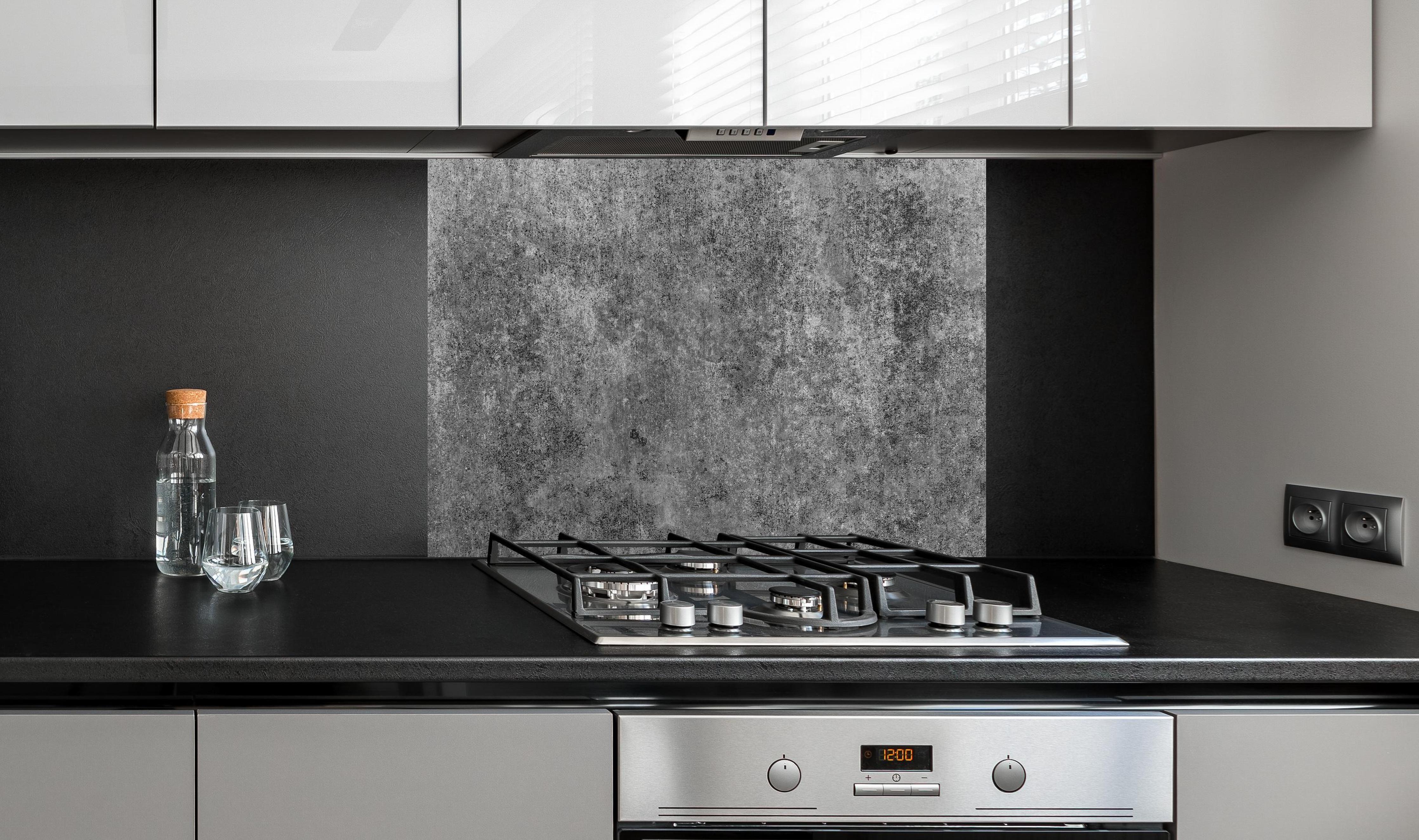 Spritzschutz - Massiver dunkelgrauer Beton an edler Anthrazit-Wand hinter silbernem Gasherd