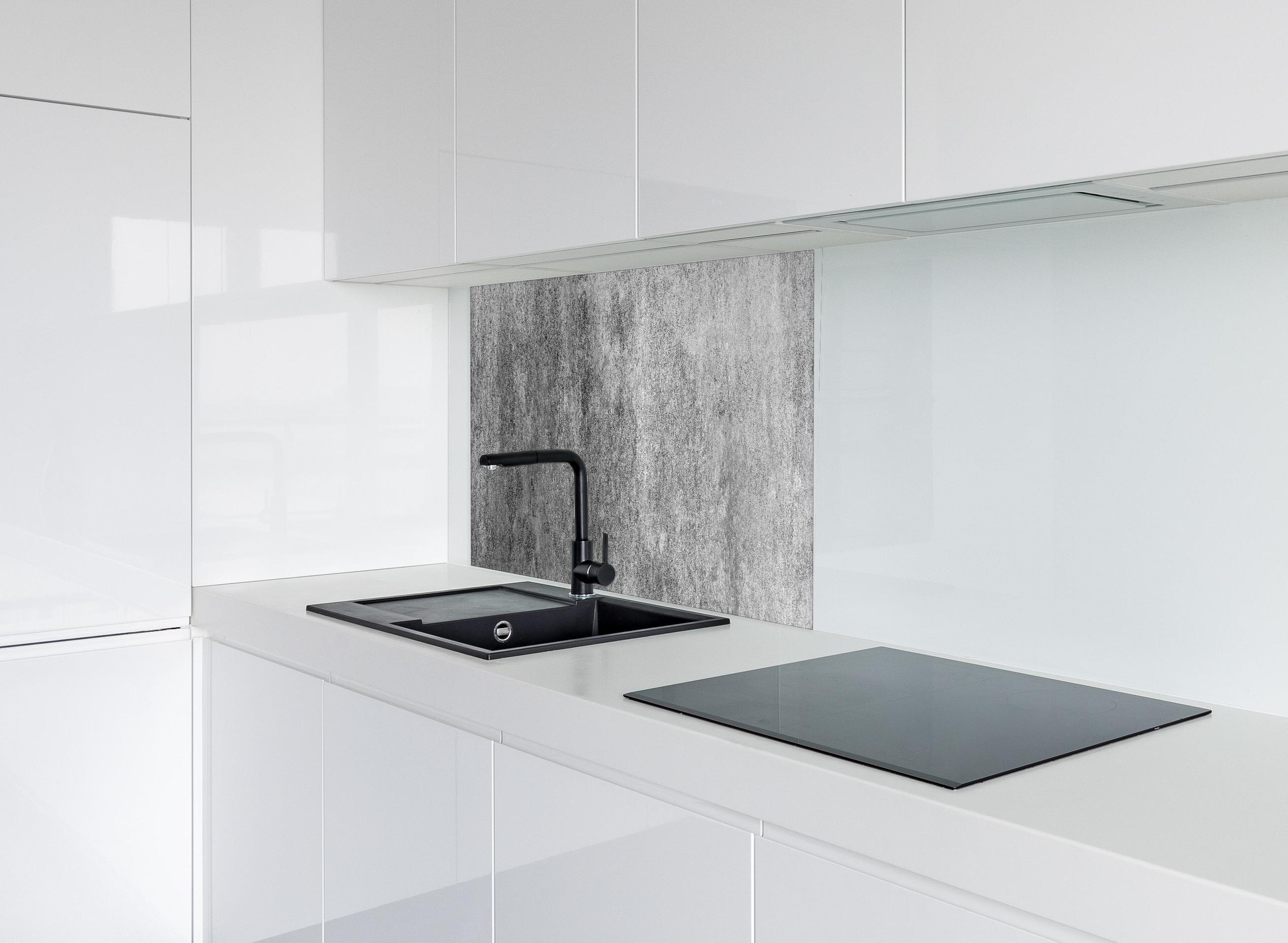 Spritzschutz - Massiver dunkelgrauer Beton hinter modernem schwarz-matten Spülbecken in weißer Hochglanz-Küche