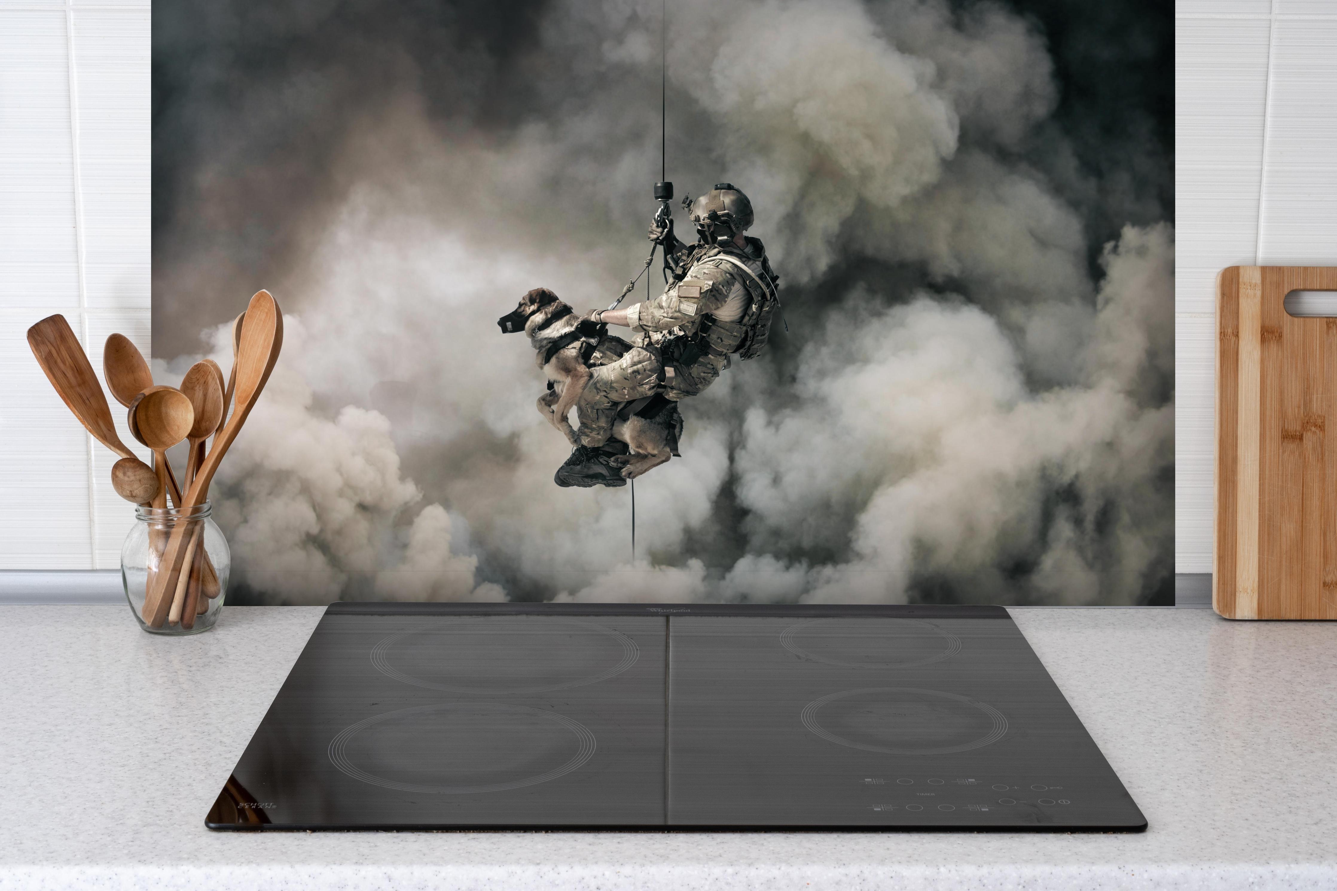 Spritzschutz - Militärsoldat mit Hund hinter einem Cerankochfeld zwischen Holz-Kochutensilien
