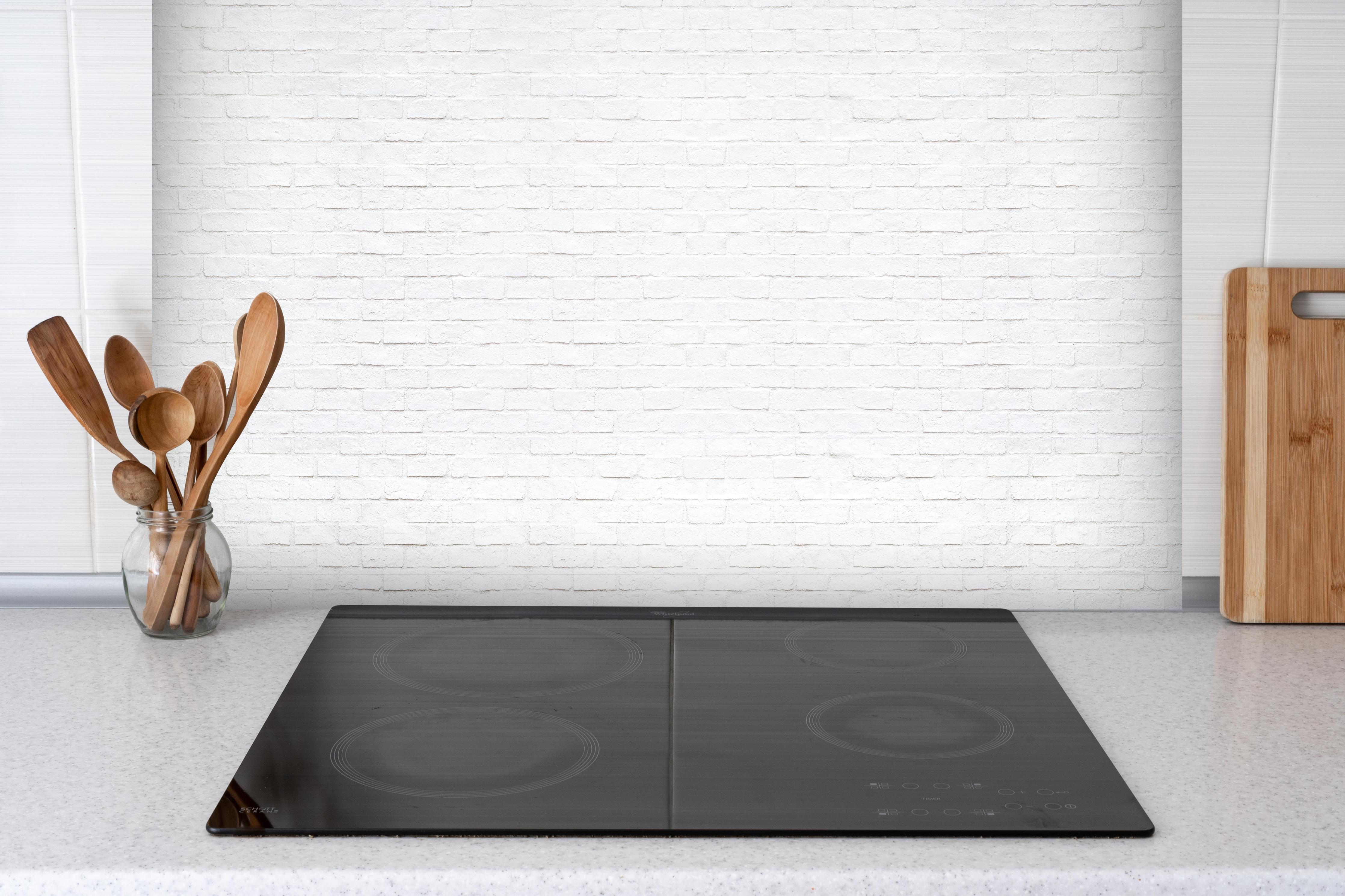 Spritzschutz - Moderne weiße Backsteinmauer 1 hinter einem Cerankochfeld zwischen Holz-Kochutensilien