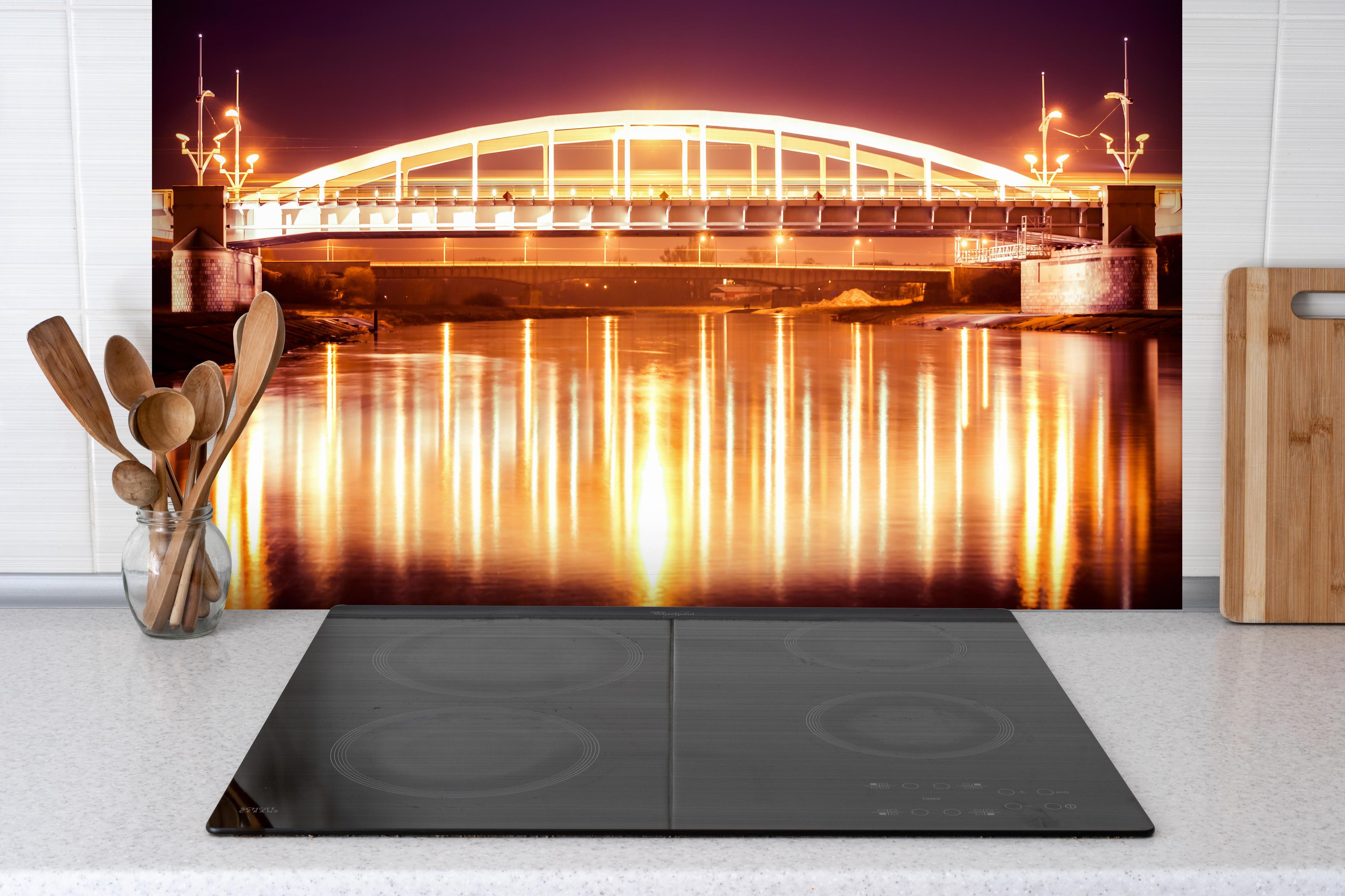 Spritzschutz - Nacht Blick auf eine Brücke über den Fluss Warta in Posen hinter einem Cerankochfeld zwischen Holz-Kochutensilien
