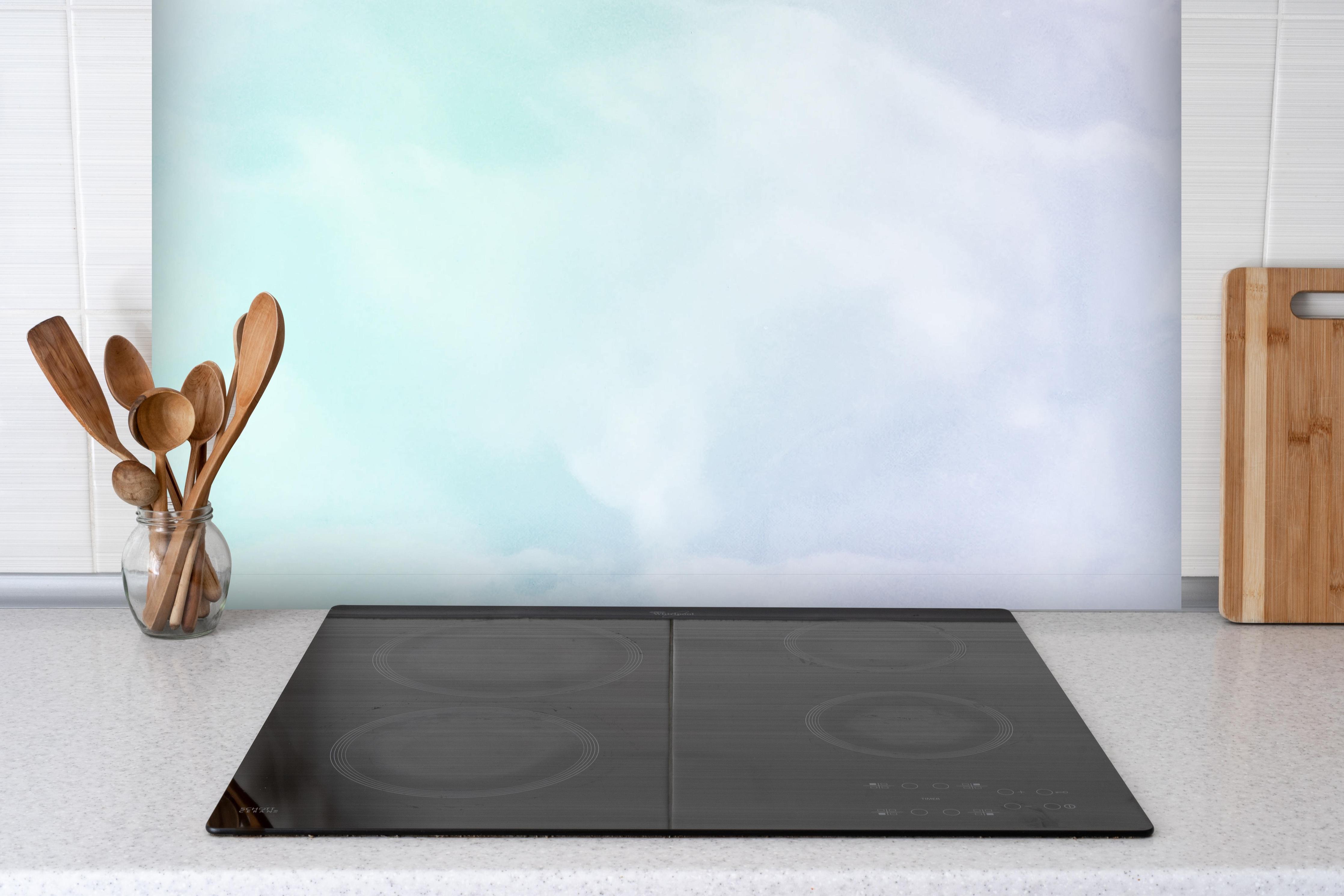 Spritzschutz - Nahaufnahme von Pastellfarbigem Marmor hinter einem Cerankochfeld zwischen Holz-Kochutensilien