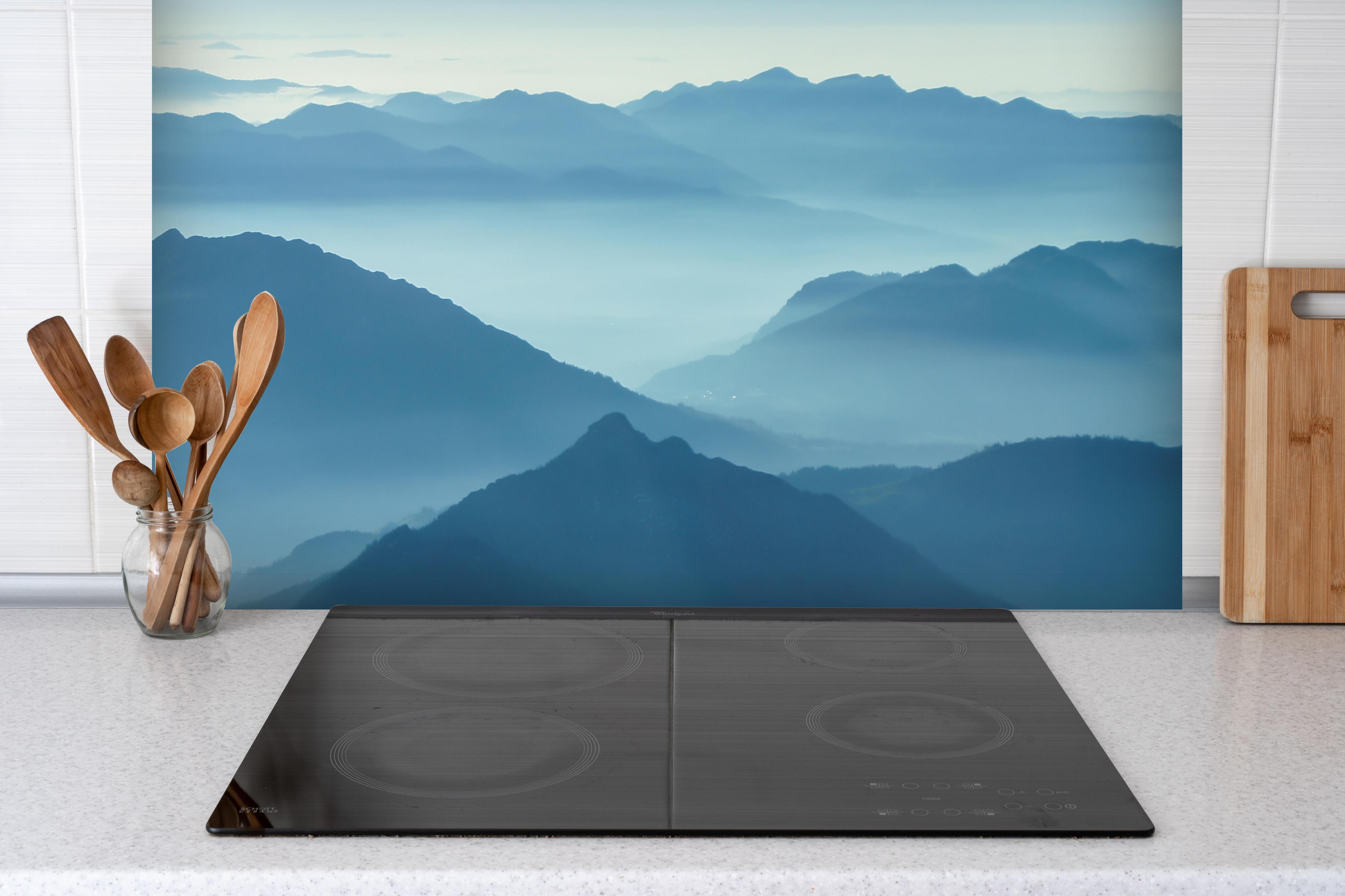 Spritzschutz - Nebelschwaden in den Tälern des Voralpenlandes hinter einem Cerankochfeld zwischen Holz-Kochutensilien