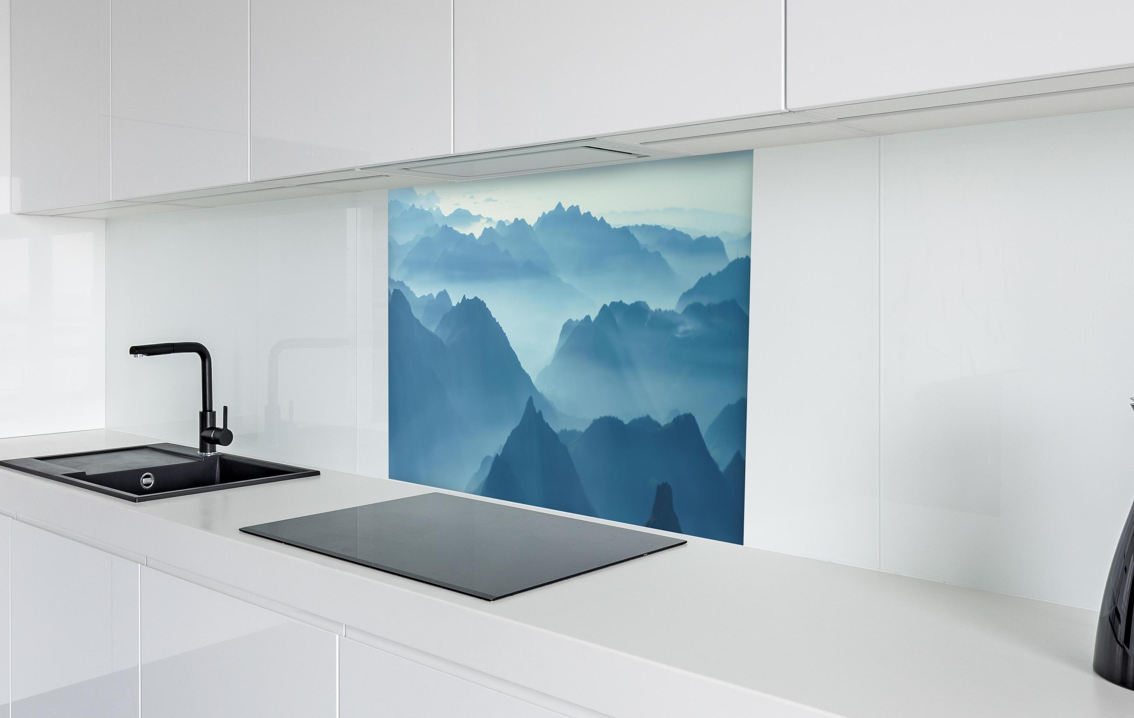 Spritzschutz - Nebelschwaden in den Tälern des Voralpenlandes in weißer Hochglanz-Küche hinter einem Cerankochfeld