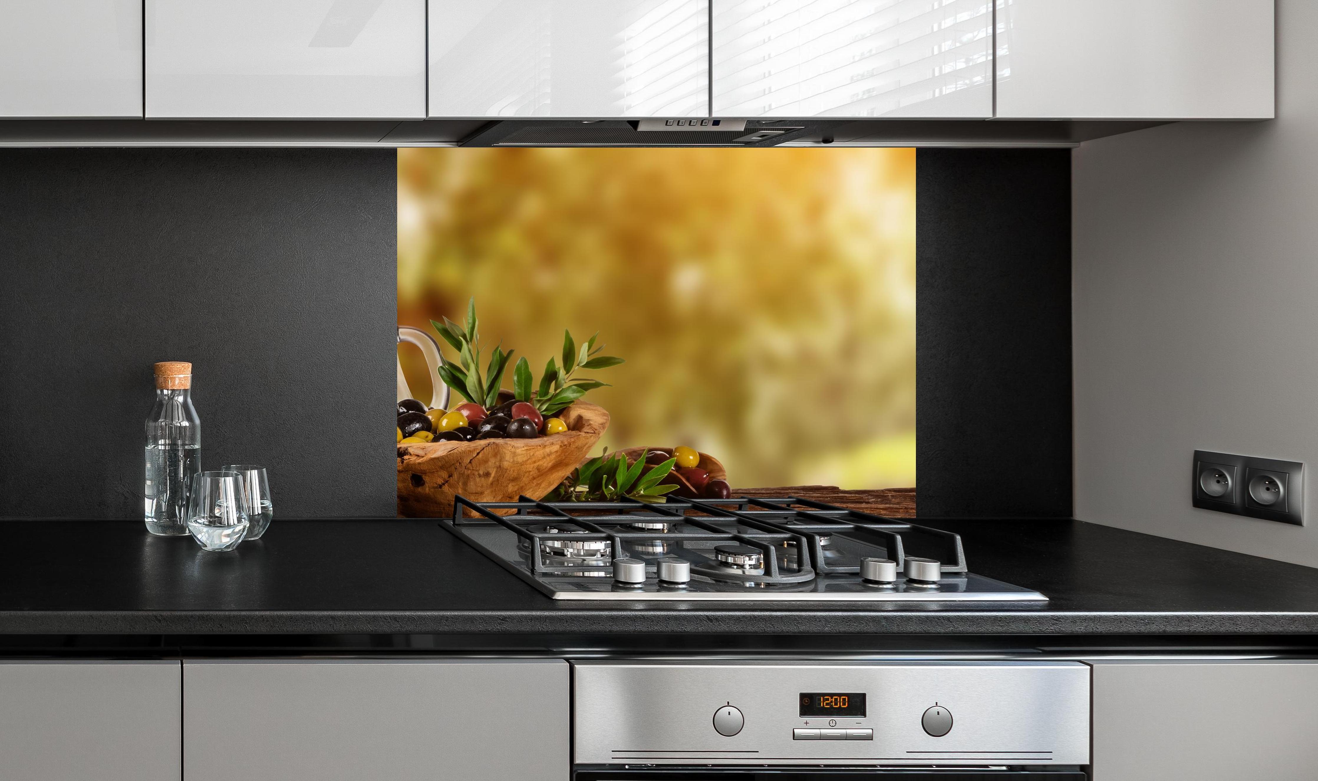 Spritzschutz - Olivenöl & Oliven an edler Anthrazit-Wand hinter silbernem Gasherd