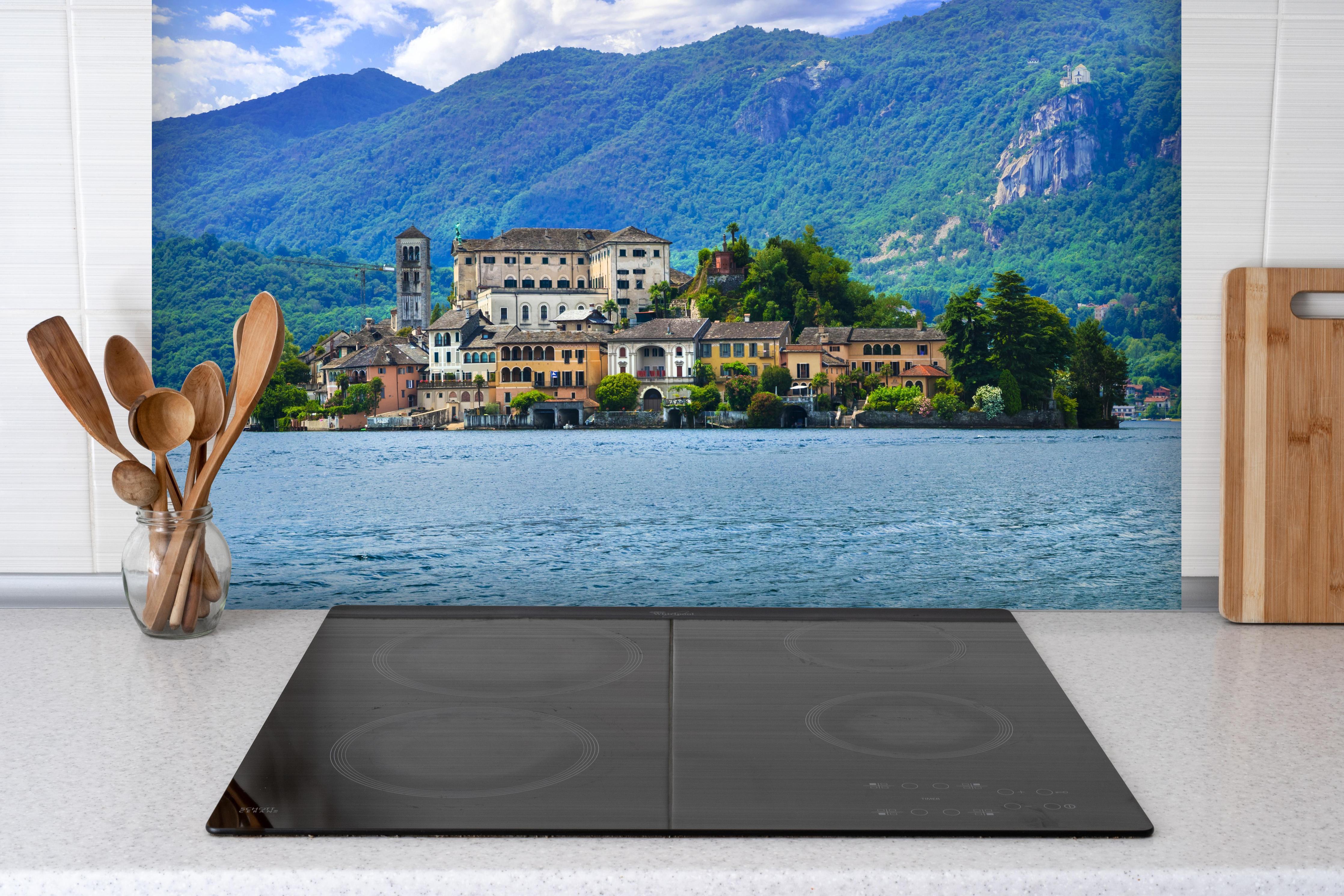 Spritzschutz - Ortasee - Italien hinter einem Cerankochfeld zwischen Holz-Kochutensilien