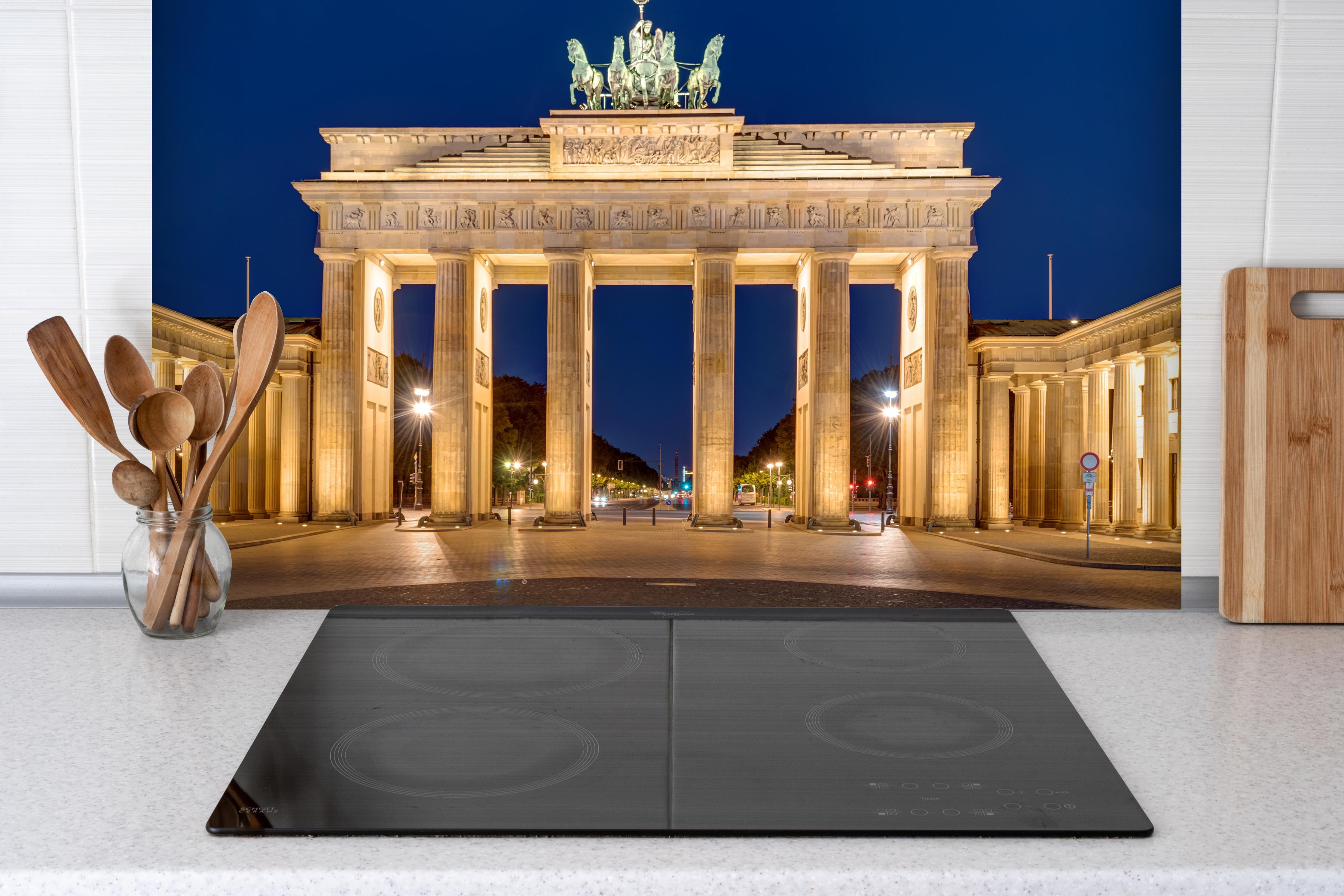 Spritzschutz - Panorama des Brandenburger Tor hinter einem Cerankochfeld zwischen Holz-Kochutensilien