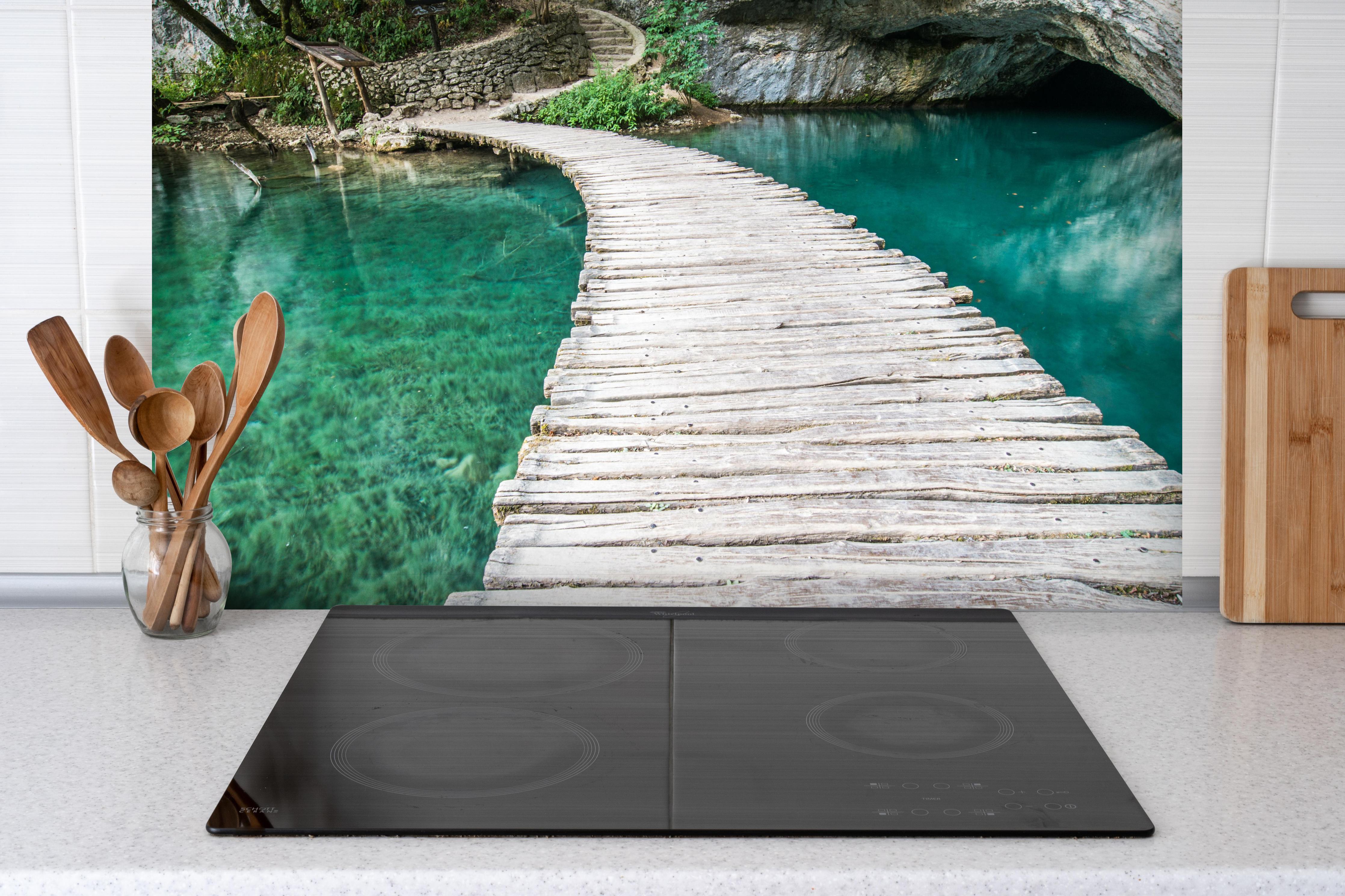 Spritzschutz - Plitvicer Brücke in Kroatien hinter einem Cerankochfeld zwischen Holz-Kochutensilien