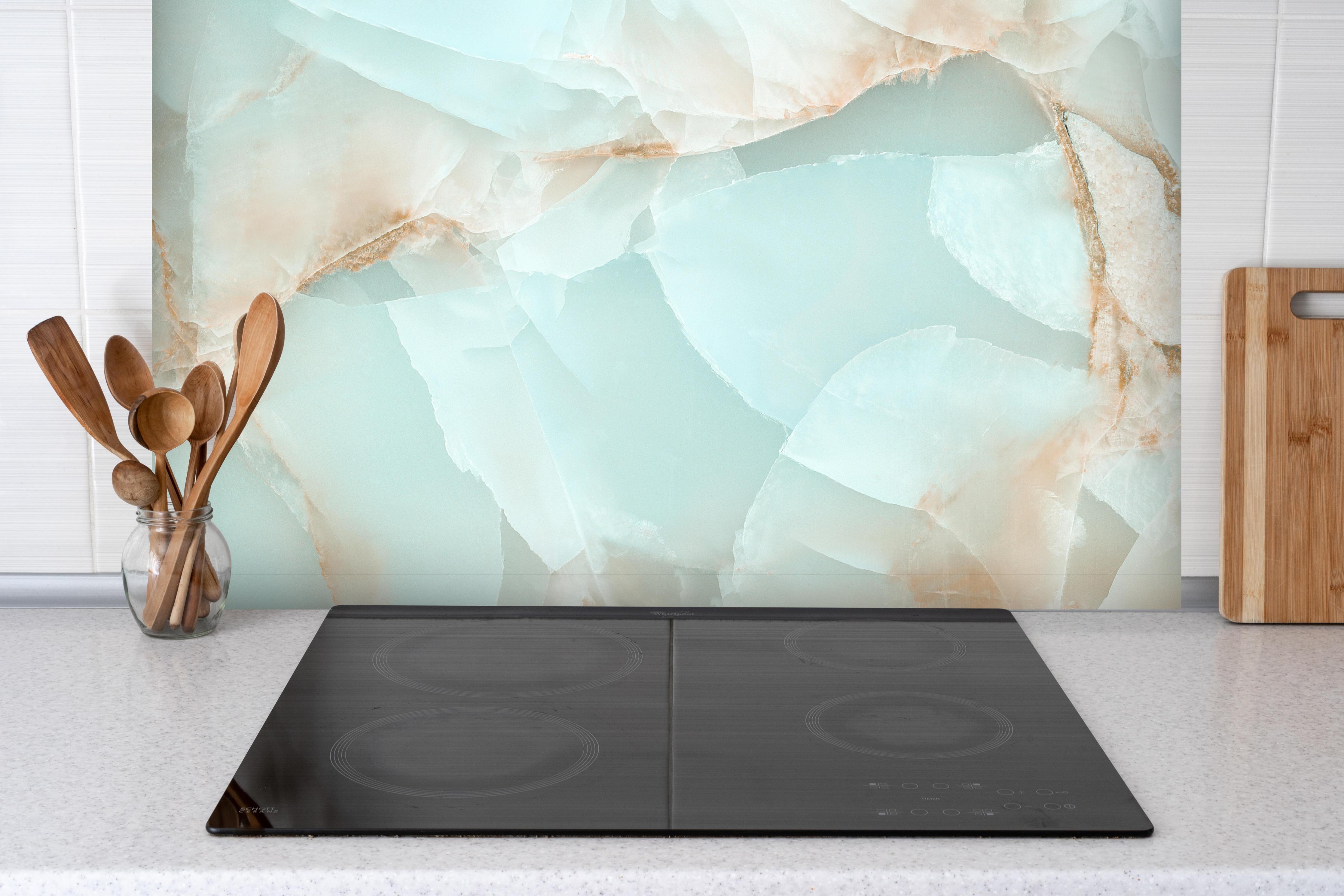 Spritzschutz - Polierter Onyx-Marmor hinter einem Cerankochfeld zwischen Holz-Kochutensilien