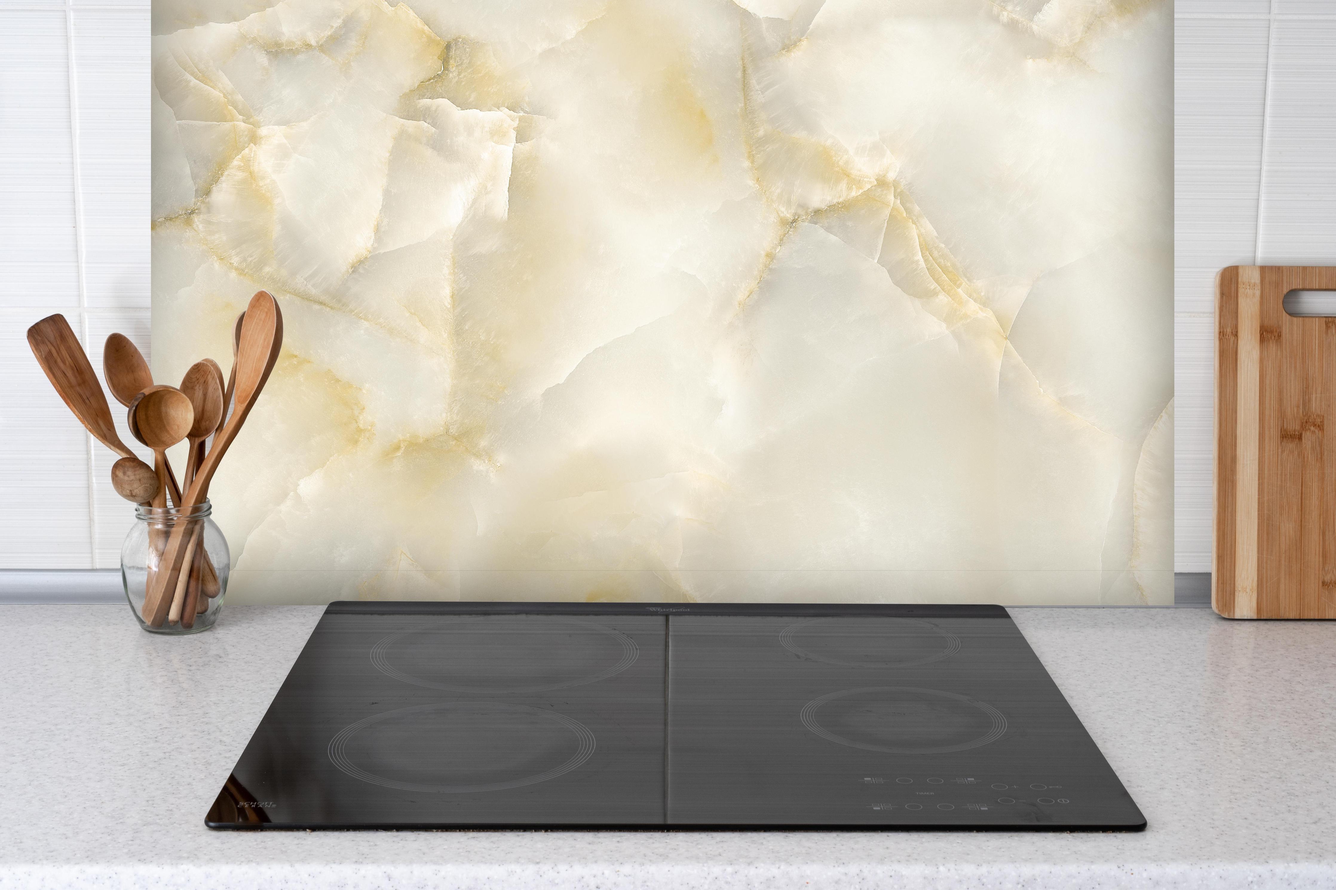 Spritzschutz - Polierter Terazzo Steinboden hinter einem Cerankochfeld zwischen Holz-Kochutensilien
