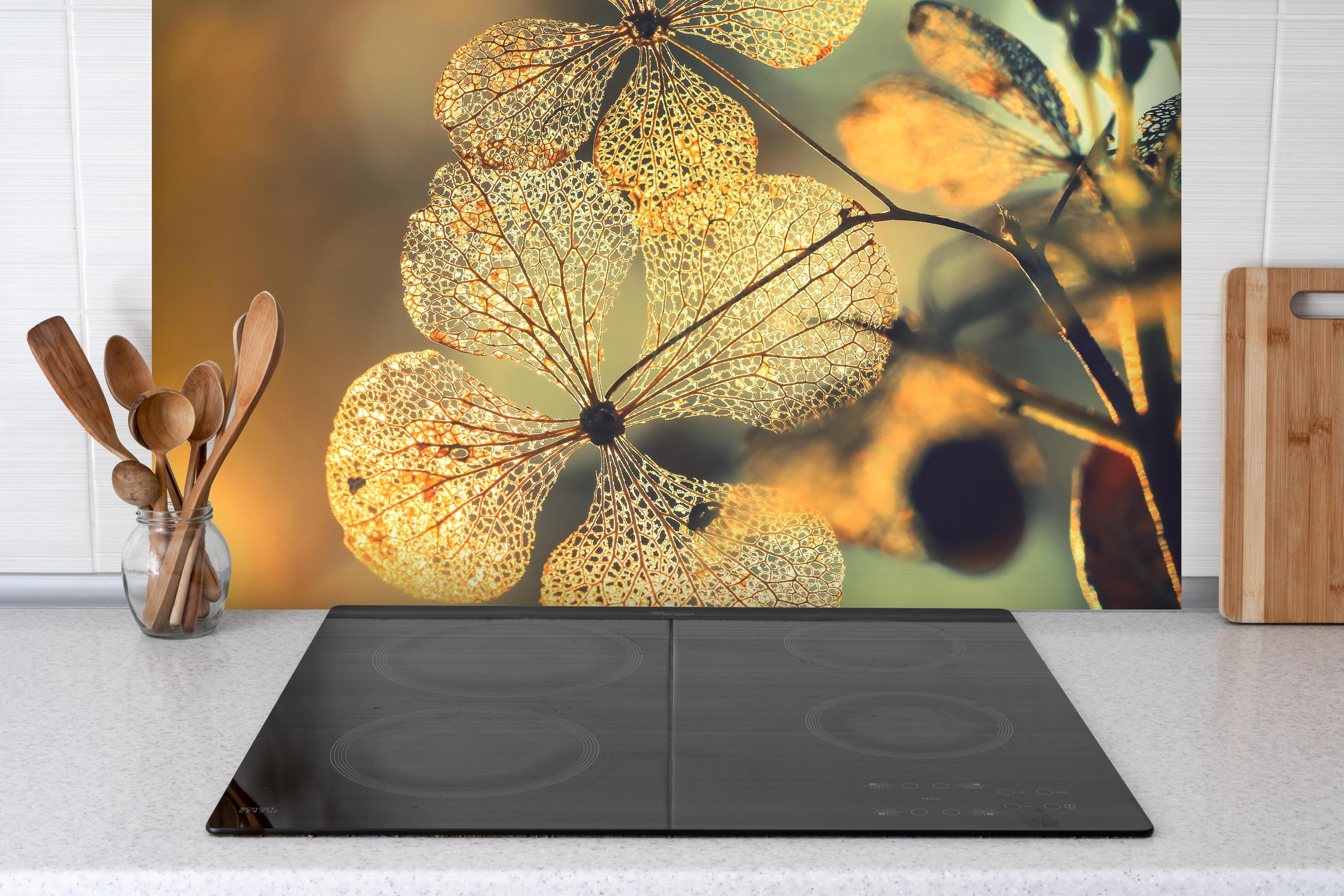 Spritzschutz - Prächtige Hortensienblüten hinter einem Cerankochfeld zwischen Holz-Kochutensilien