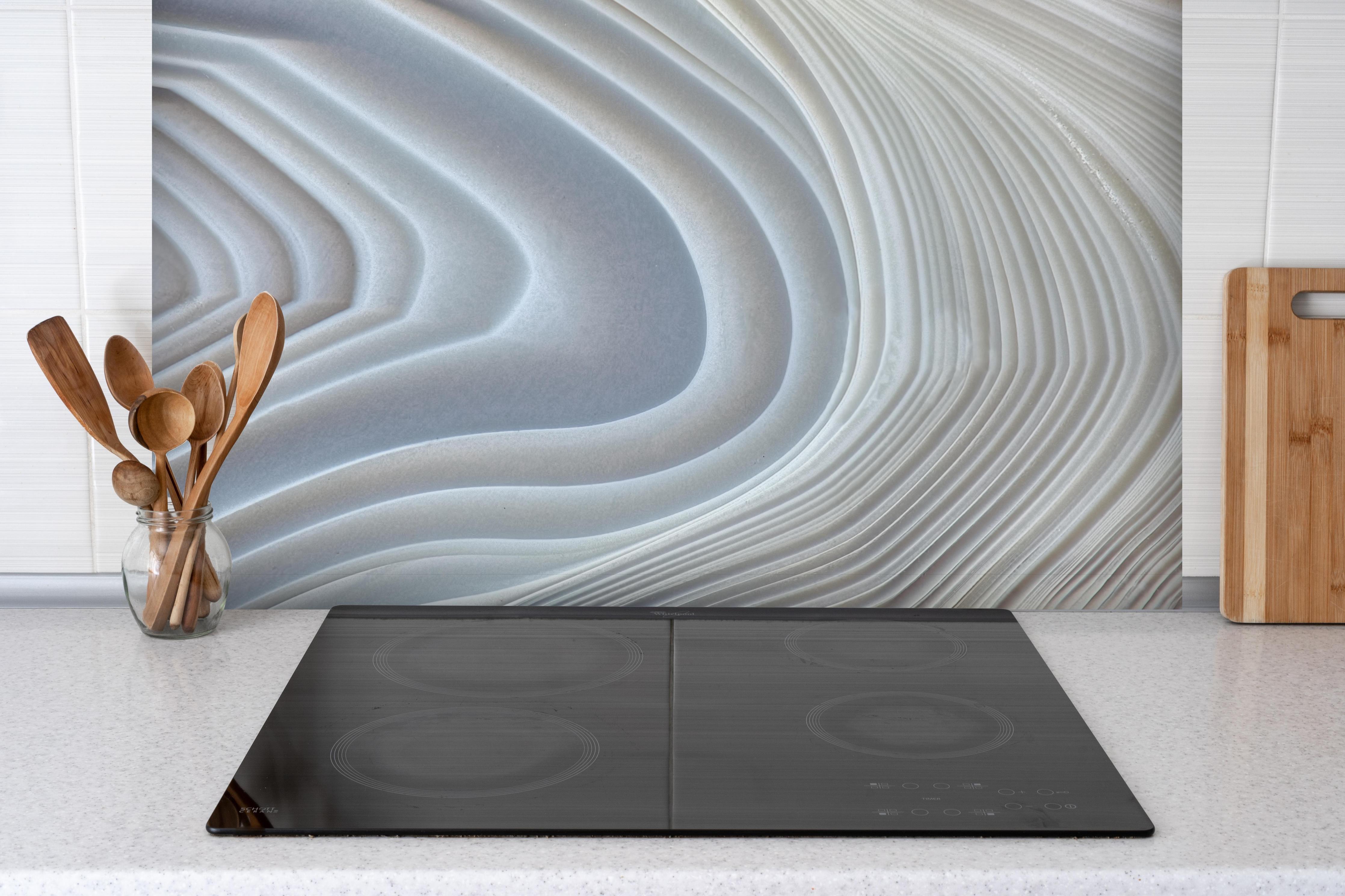 Spritzschutz - Querschnitt eines Achatkristalls hinter einem Cerankochfeld zwischen Holz-Kochutensilien