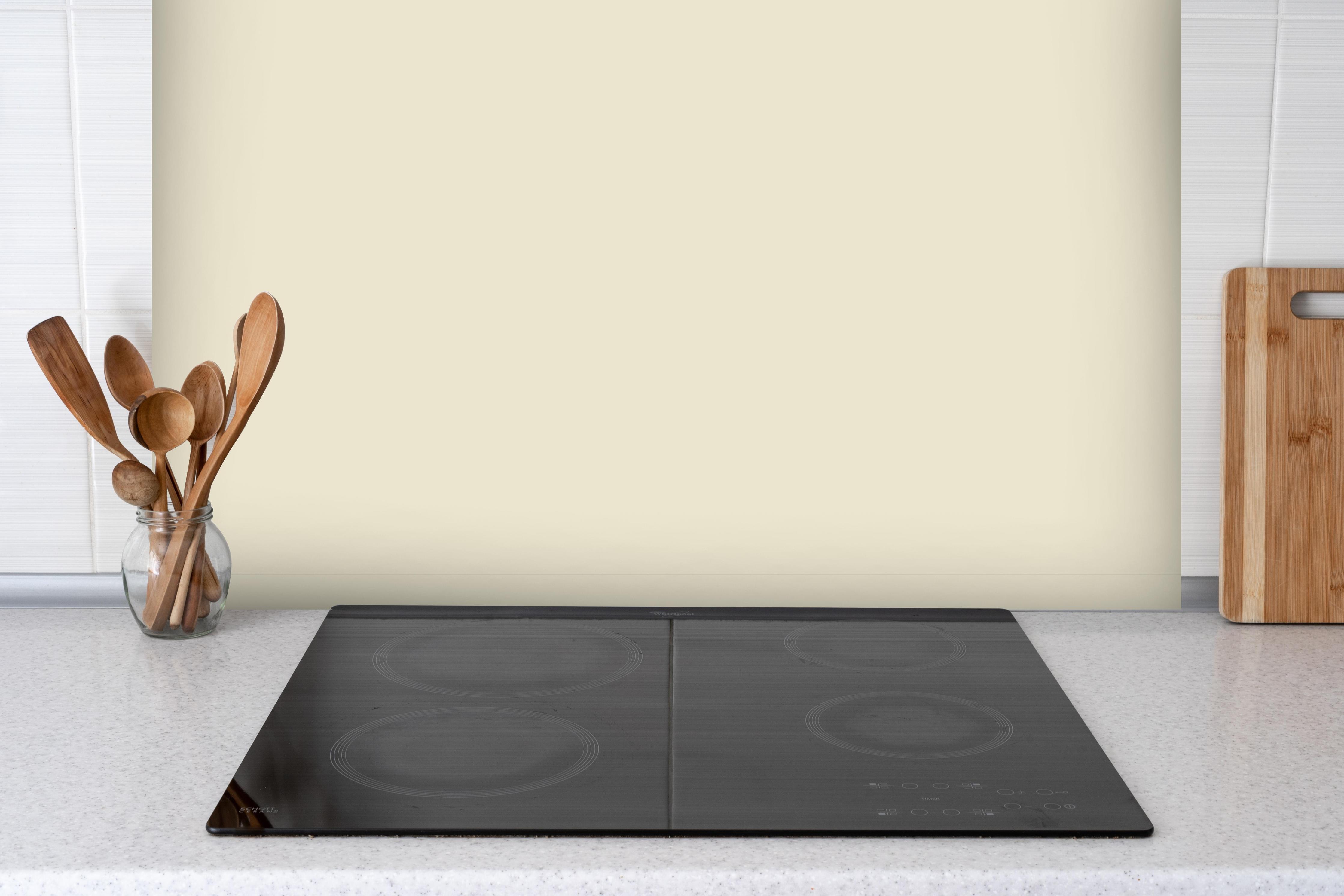 Spritzschutz - RAL 1013 (Austernweiß) hinter einem Cerankochfeld zwischen Holz-Kochutensilien