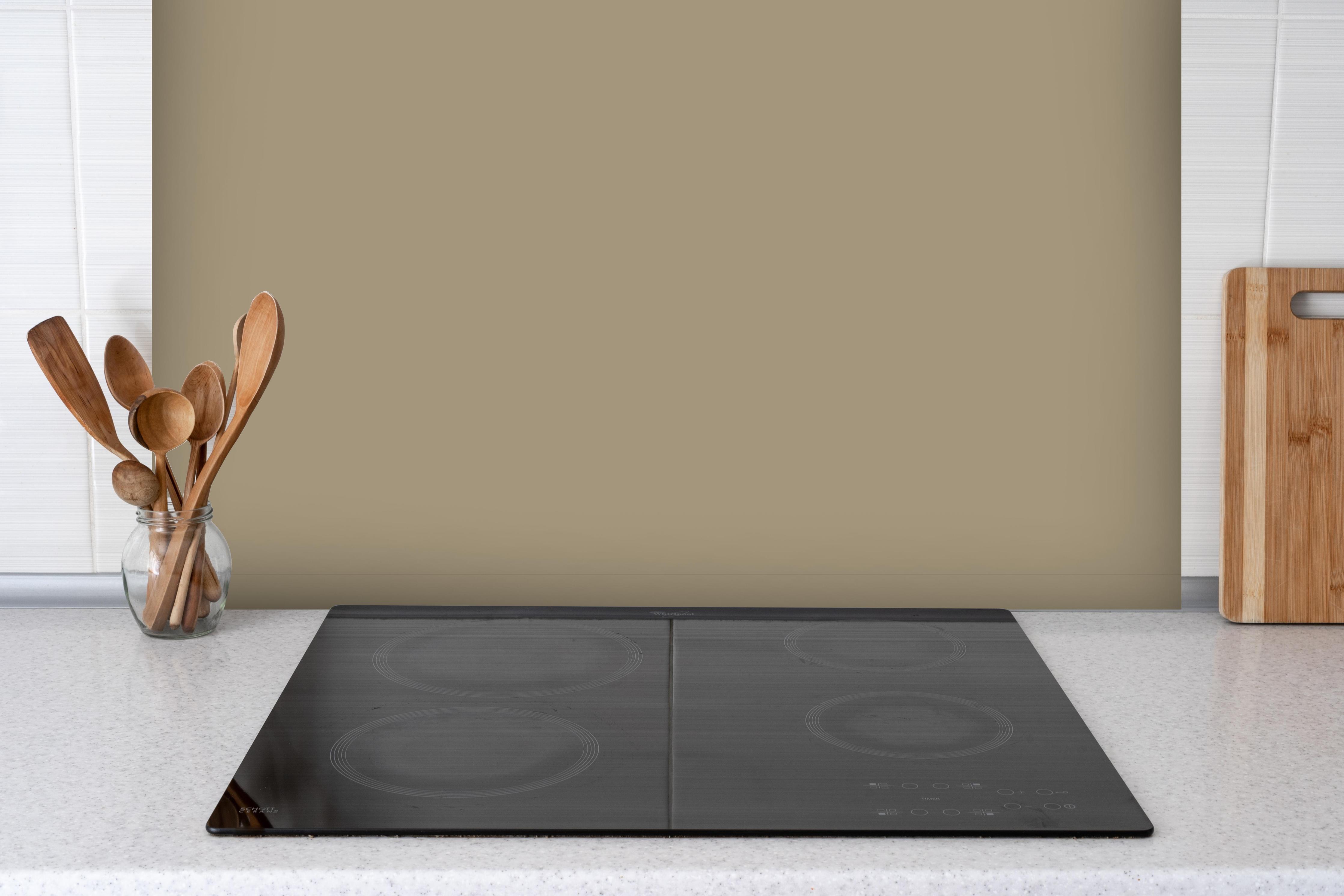 Spritzschutz - RAL 1019 (Graubeige) hinter einem Cerankochfeld zwischen Holz-Kochutensilien