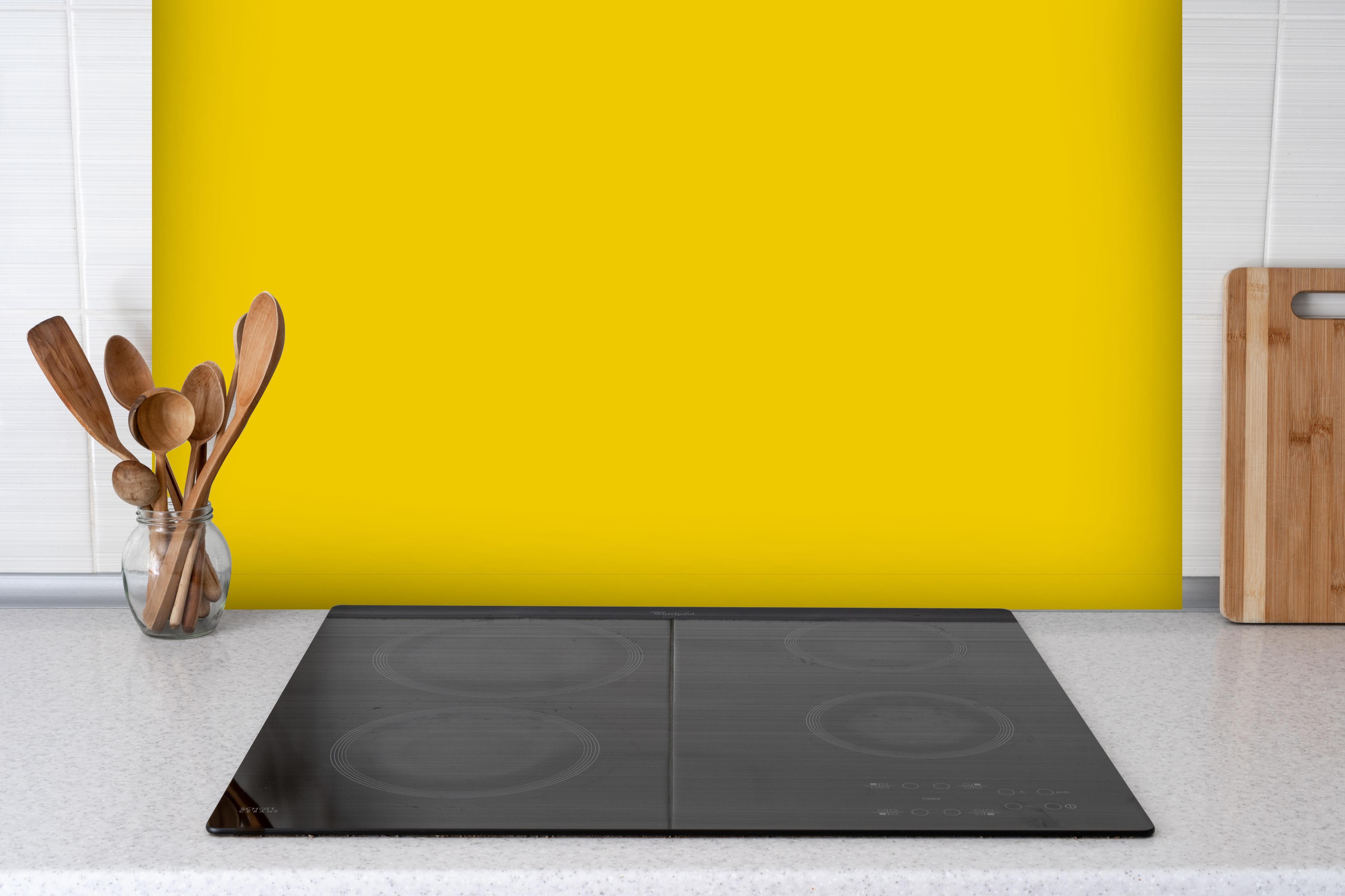 Spritzschutz - RAL 1021 (Rapsgelb) hinter einem Cerankochfeld zwischen Holz-Kochutensilien