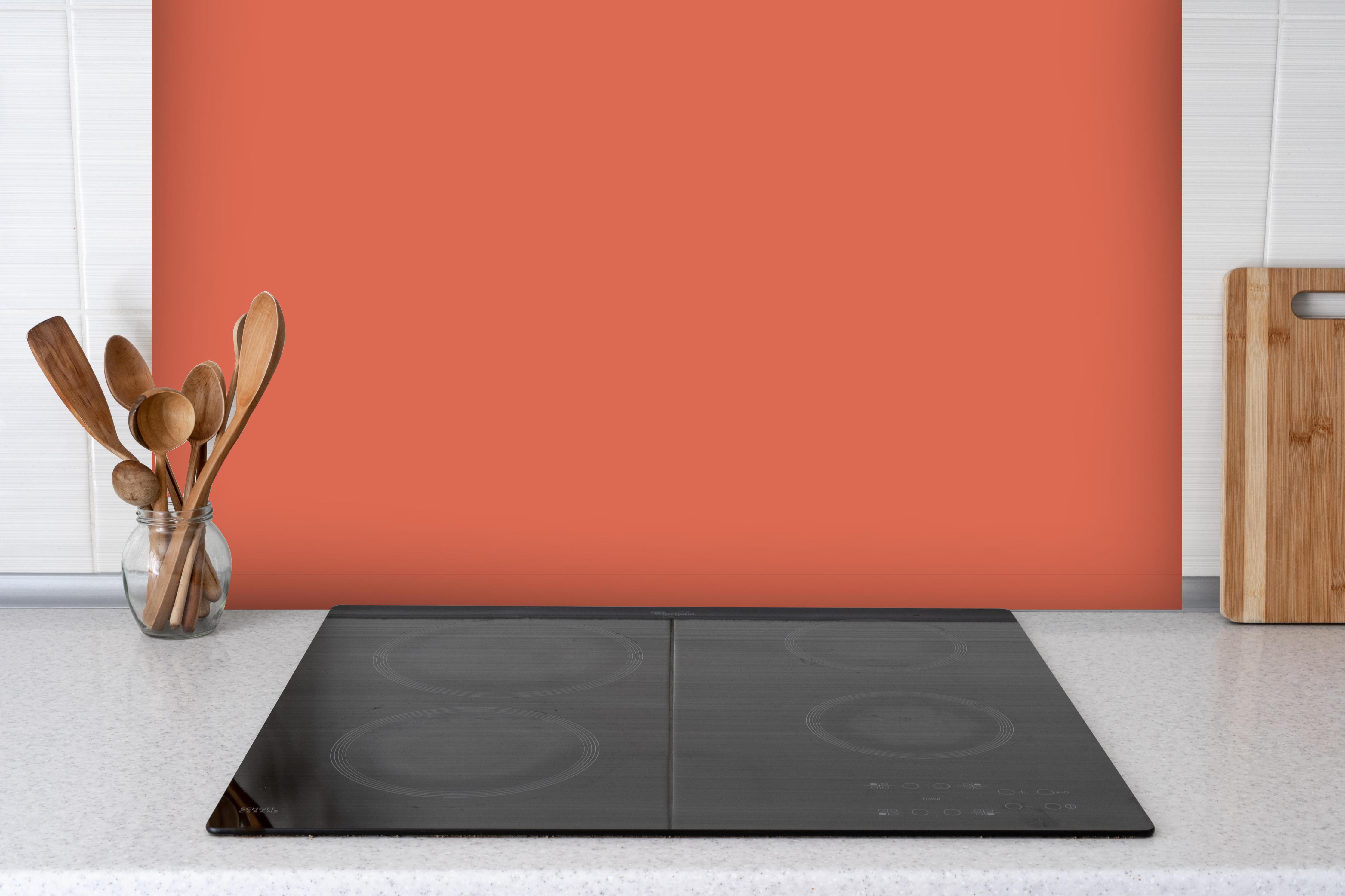 Spritzschutz - RAL 2012 (Lachsorange) hinter einem Cerankochfeld zwischen Holz-Kochutensilien