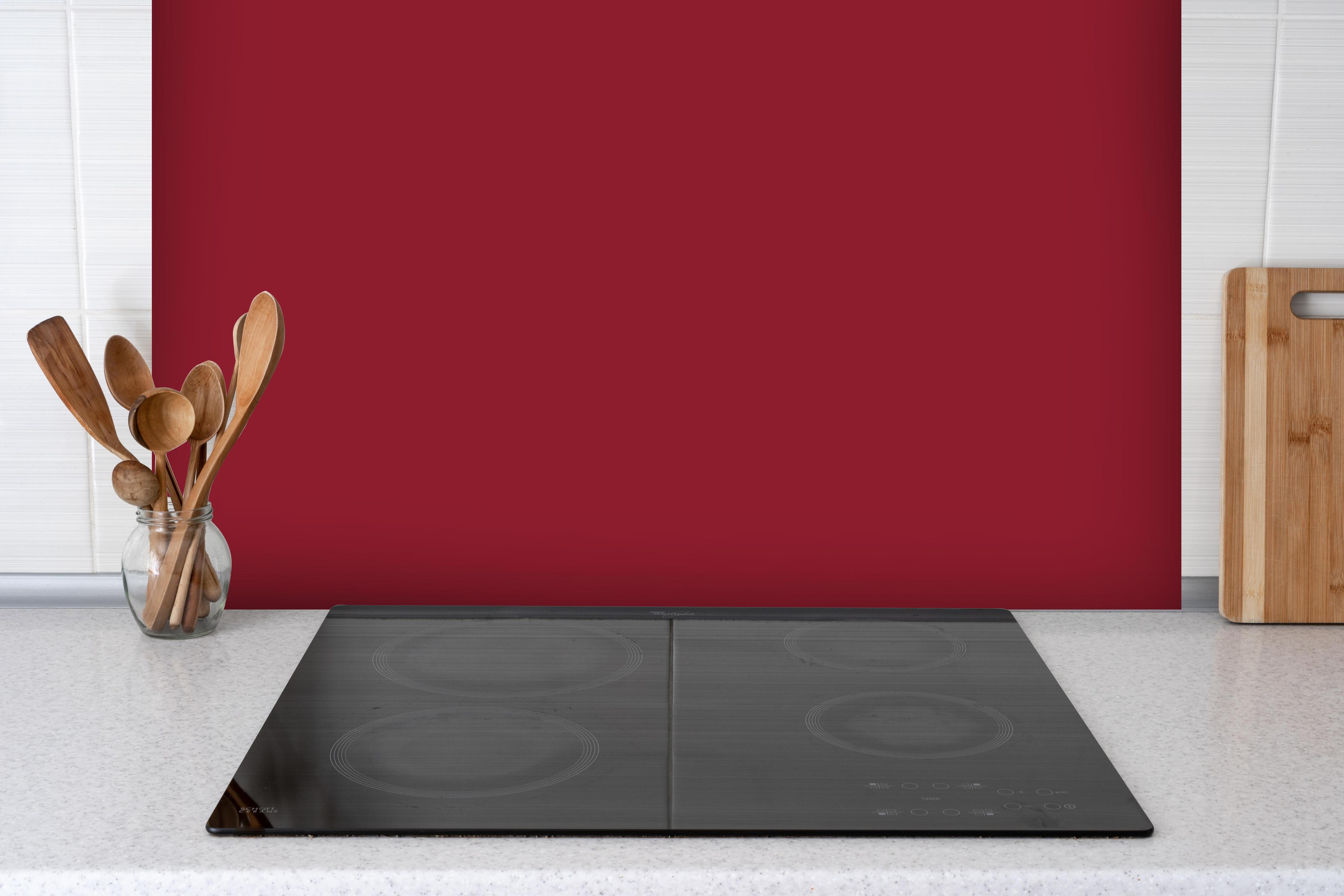 Spritzschutz - RAL 3003 (Rubinrot) hinter einem Cerankochfeld zwischen Holz-Kochutensilien