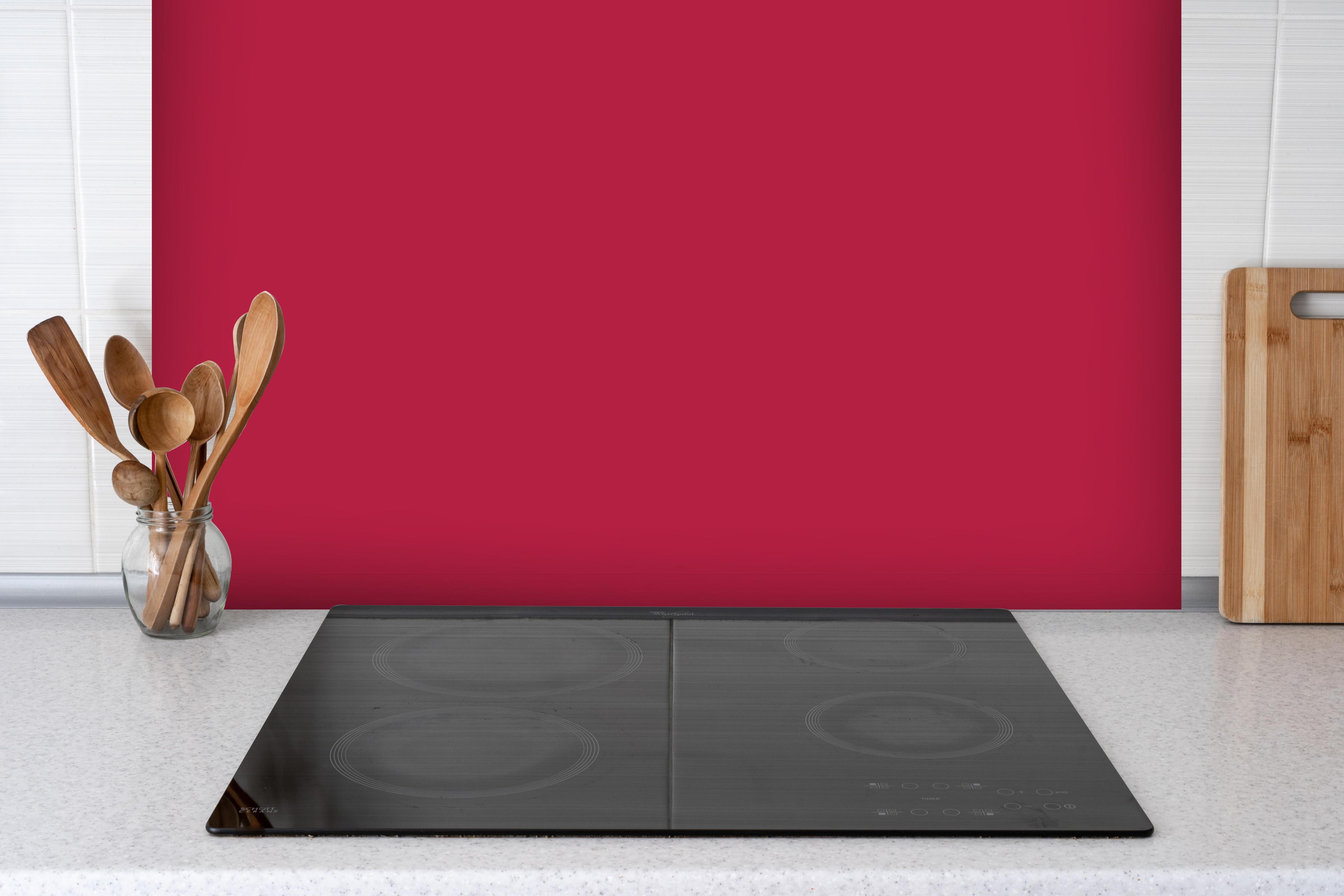 Spritzschutz - RAL 3027 (Himbeerrot) hinter einem Cerankochfeld zwischen Holz-Kochutensilien