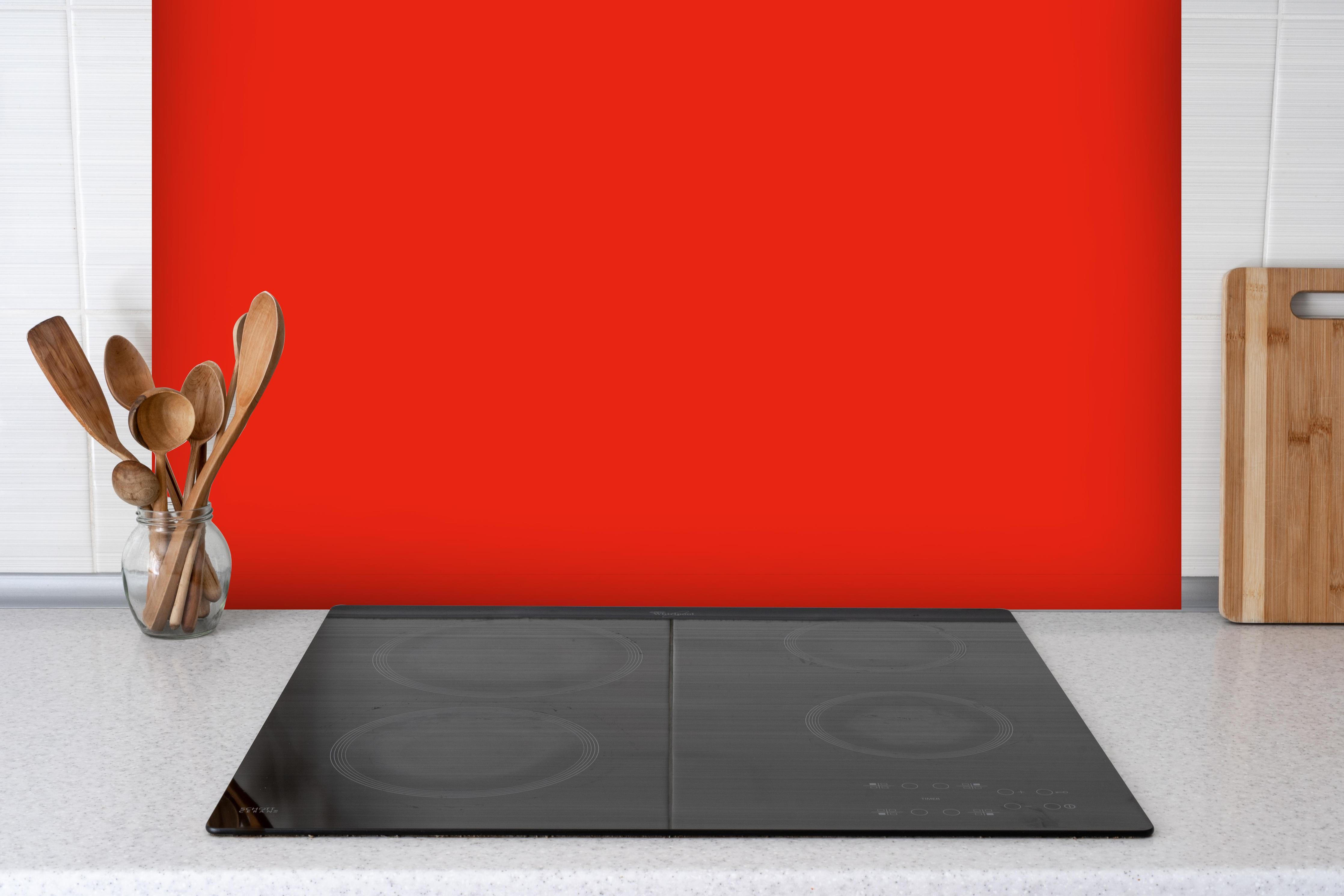 Spritzschutz - RAL 3028 (Reines Rot) hinter einem Cerankochfeld zwischen Holz-Kochutensilien