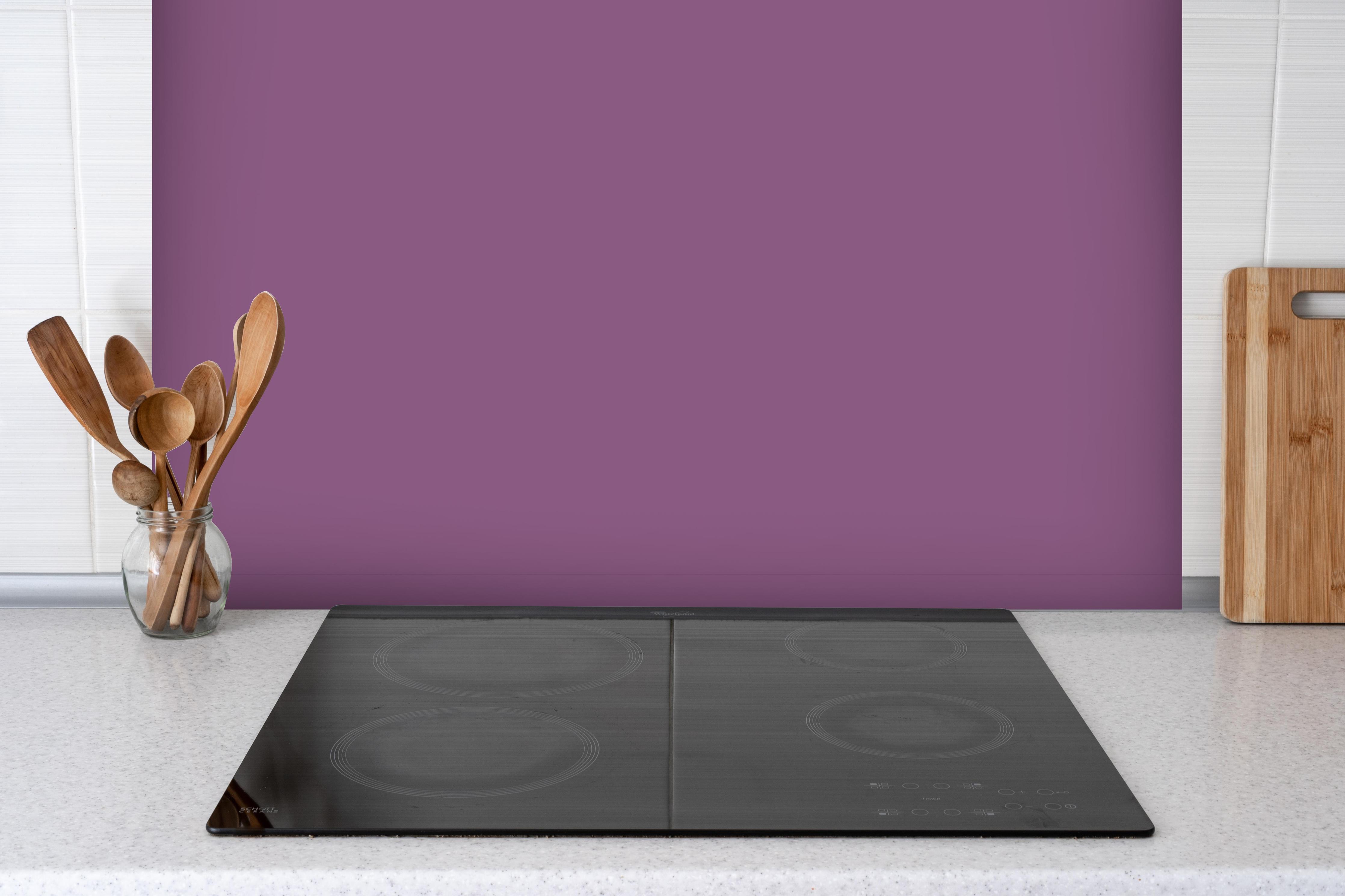 Spritzschutz - RAL 4001 (Rotflieder) hinter einem Cerankochfeld zwischen Holz-Kochutensilien