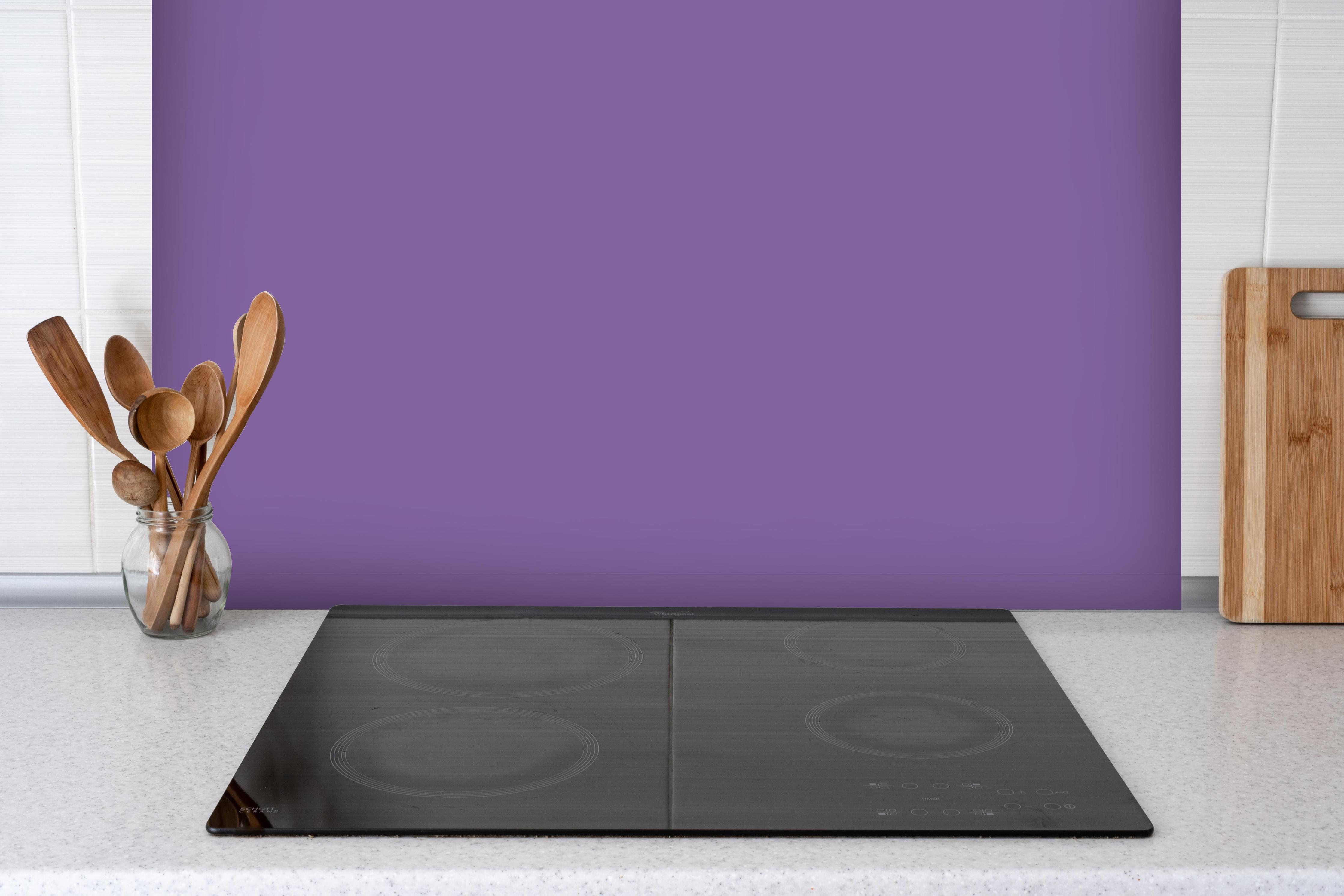 Spritzschutz - RAL 4005 (Fliederblau) hinter einem Cerankochfeld zwischen Holz-Kochutensilien