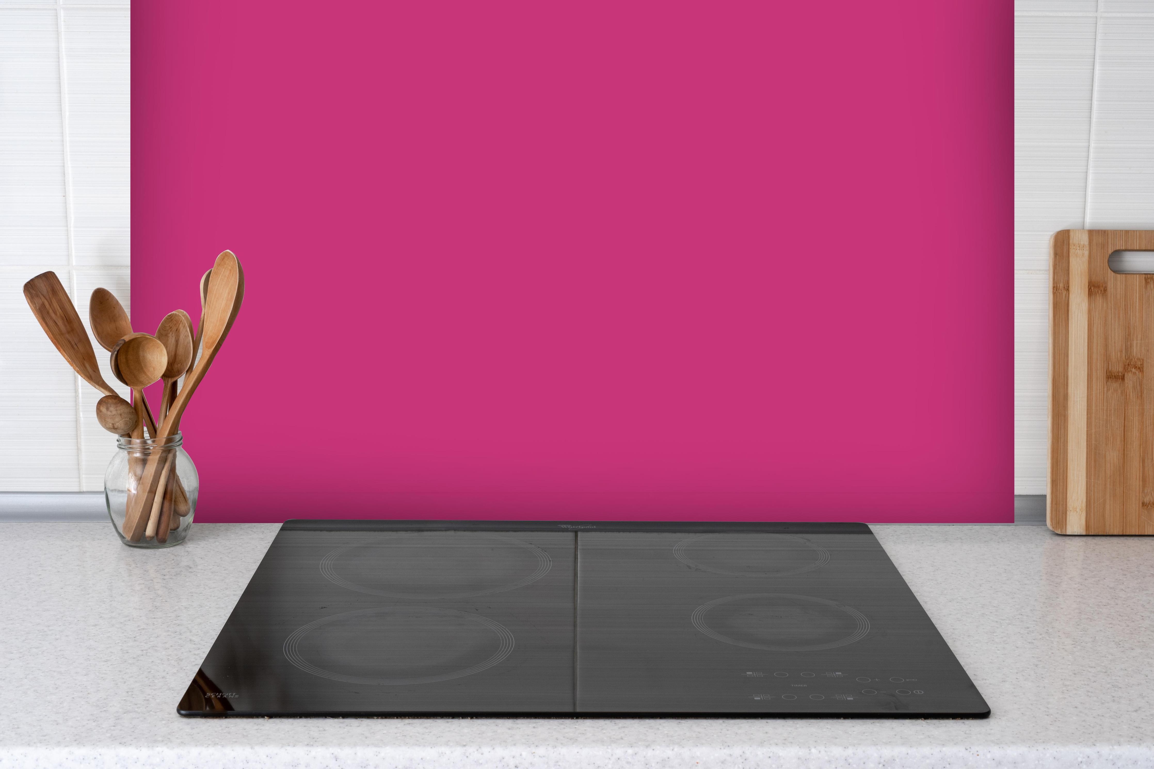 Spritzschutz - RAL 4010 (Telemagenta) hinter einem Cerankochfeld zwischen Holz-Kochutensilien