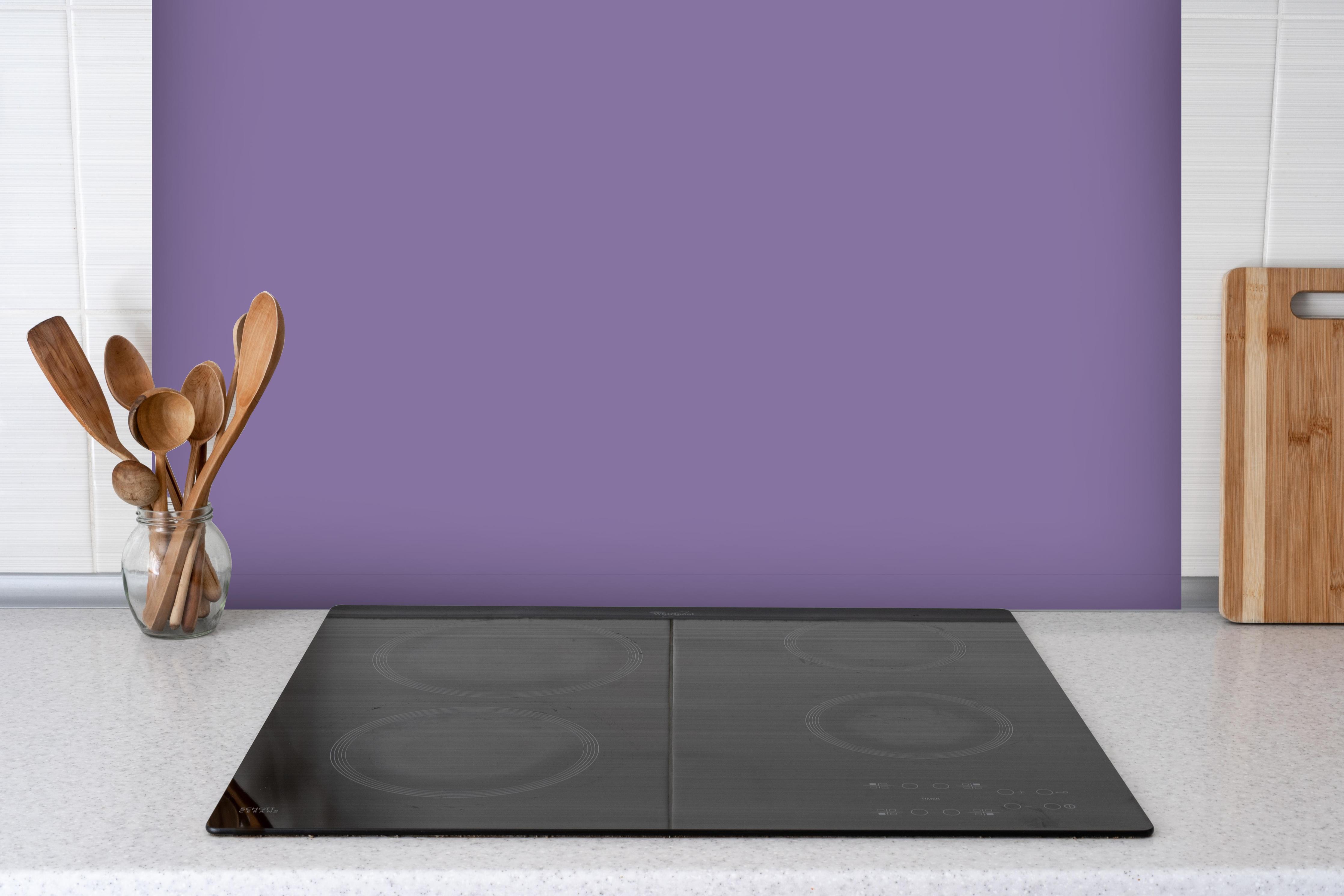 Spritzschutz - RAL 4011 (Perlviolett) hinter einem Cerankochfeld zwischen Holz-Kochutensilien