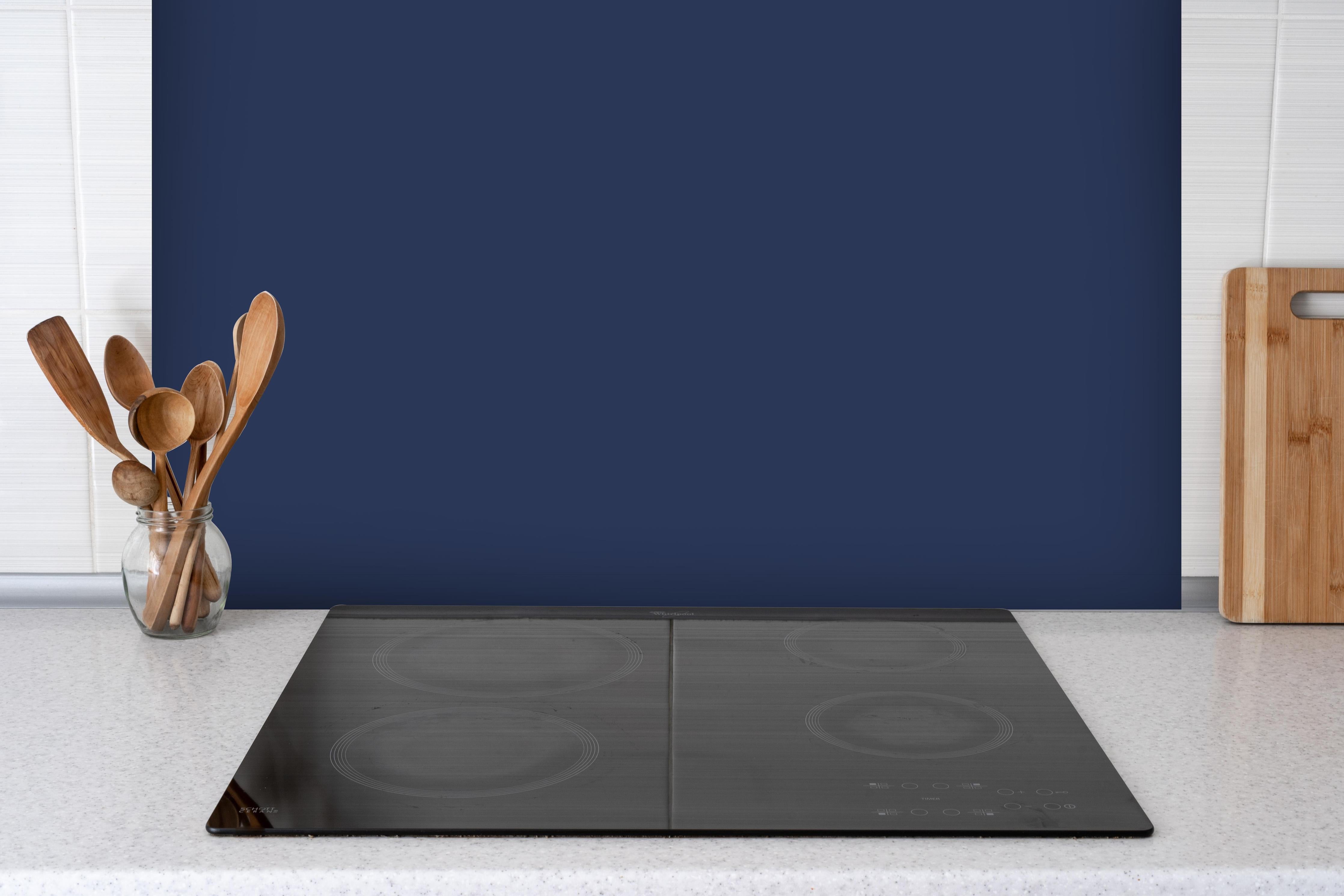 Spritzschutz - RAL 5003 (Saphirblau) hinter einem Cerankochfeld zwischen Holz-Kochutensilien