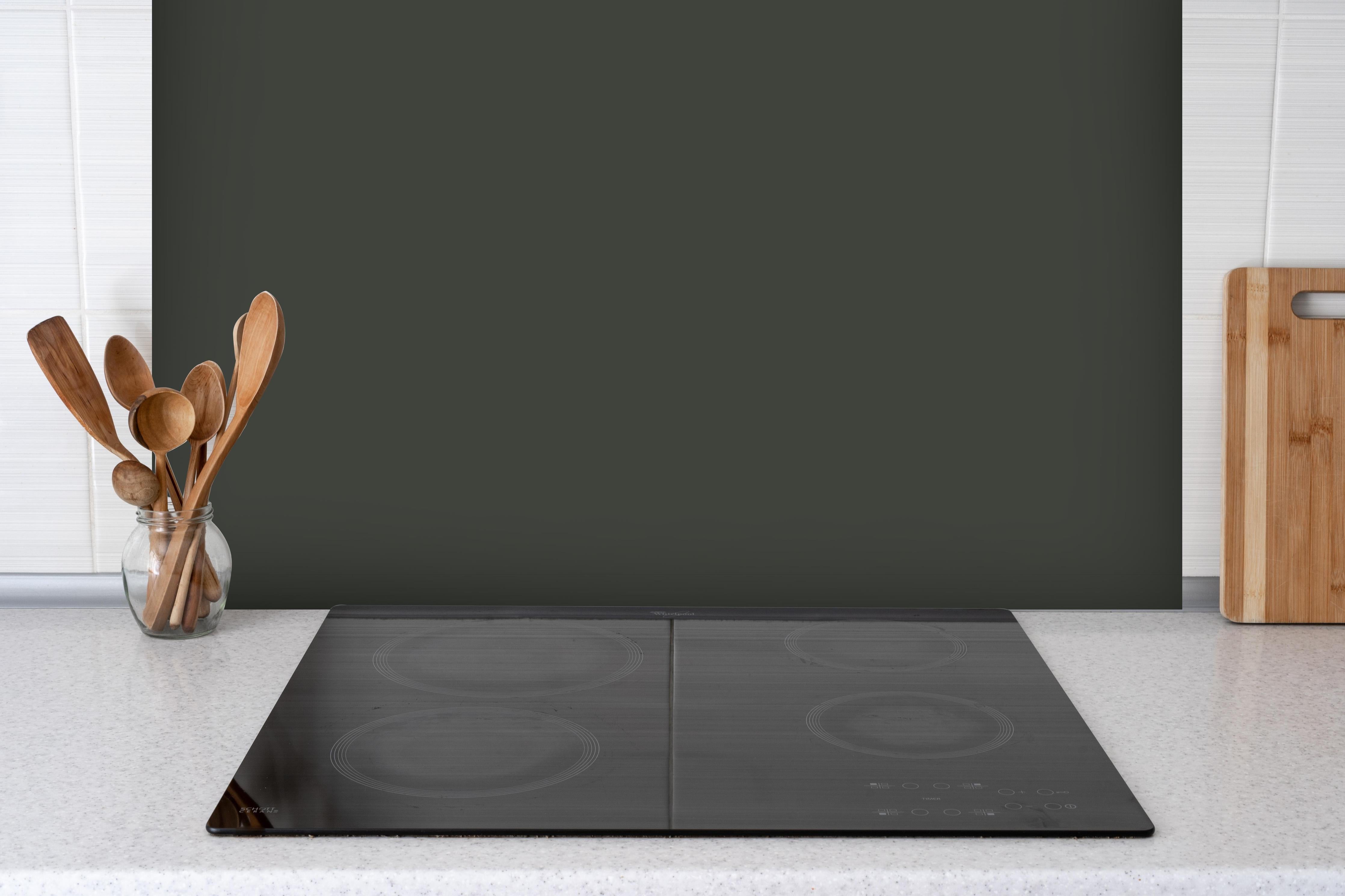 Spritzschutz - RAL 6006 (Olivgrau) hinter einem Cerankochfeld zwischen Holz-Kochutensilien