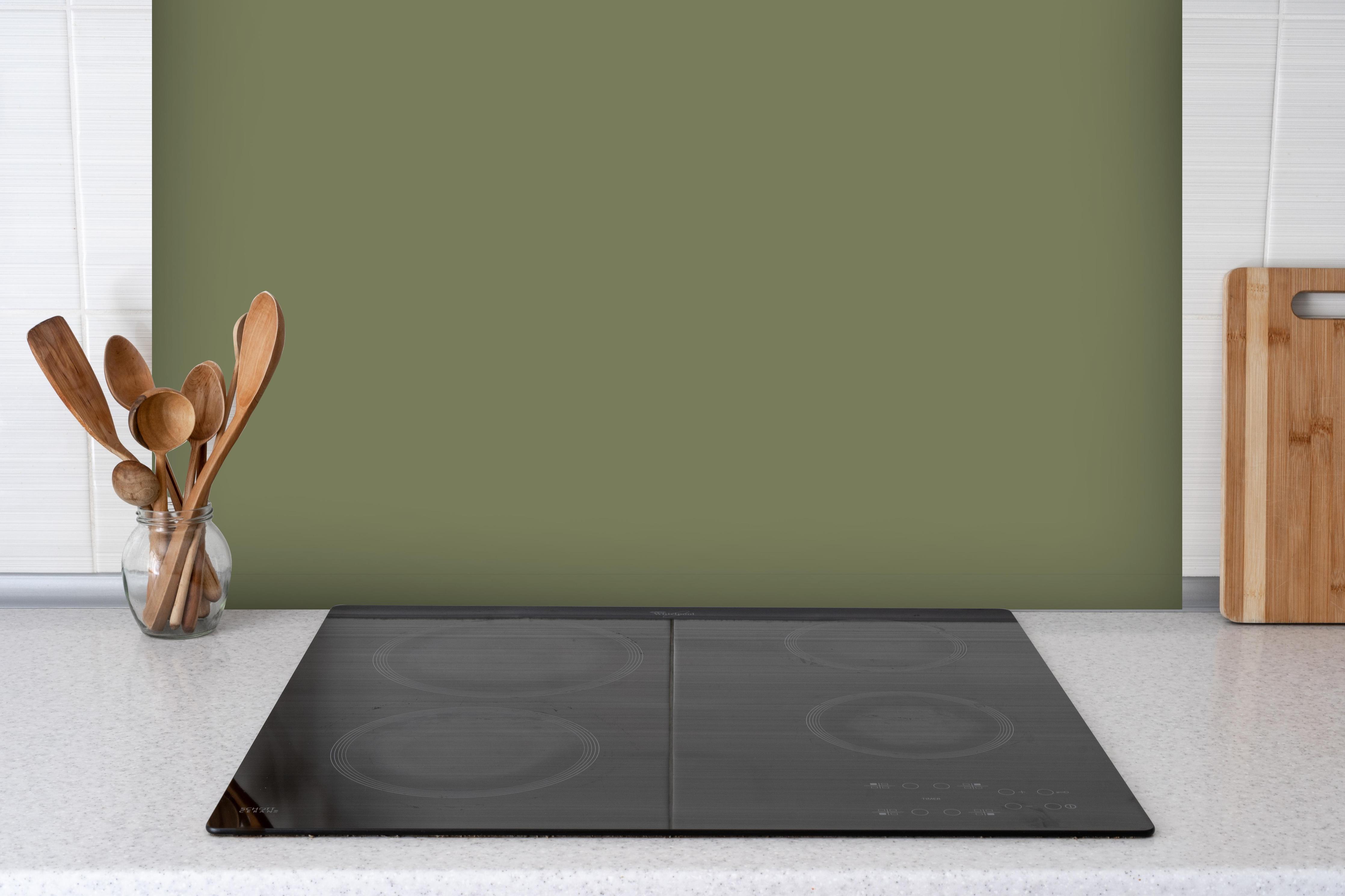 Spritzschutz - RAL 6013 (Schilfgrün) hinter einem Cerankochfeld zwischen Holz-Kochutensilien