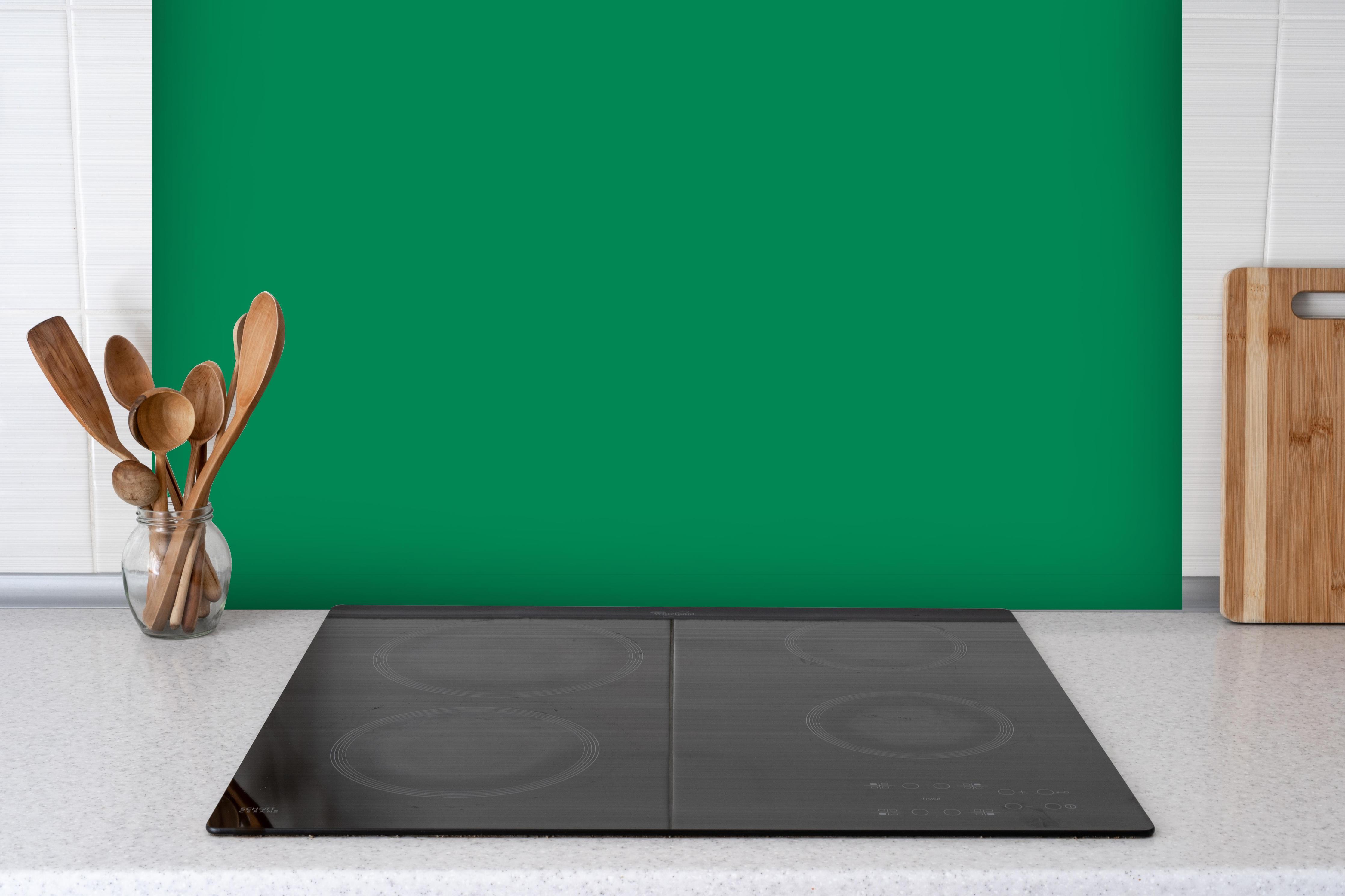 Spritzschutz - RAL 6024 (Verkehrsgrün) hinter einem Cerankochfeld zwischen Holz-Kochutensilien