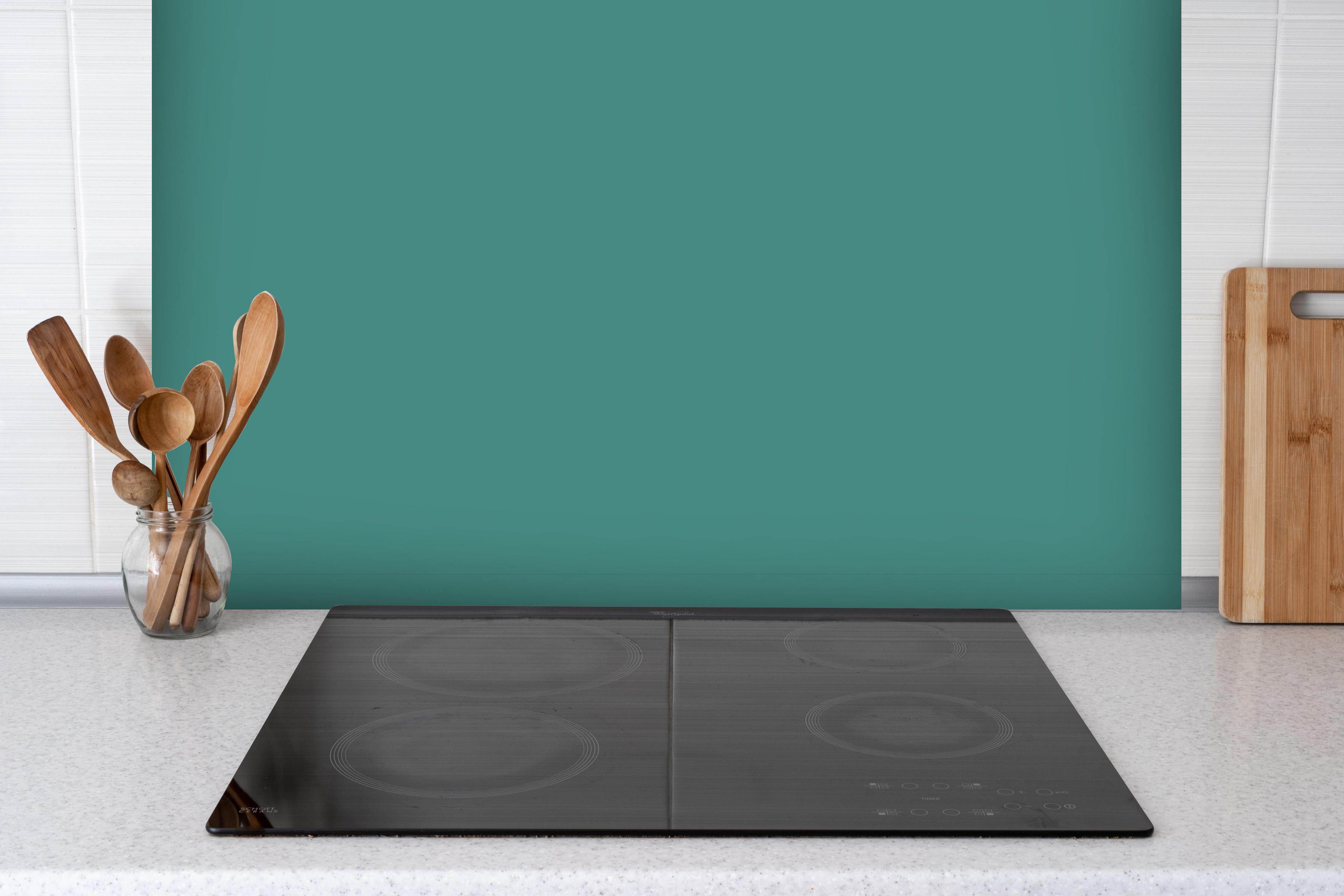 Spritzschutz - RAL 6033 (Minttürkis) hinter einem Cerankochfeld zwischen Holz-Kochutensilien