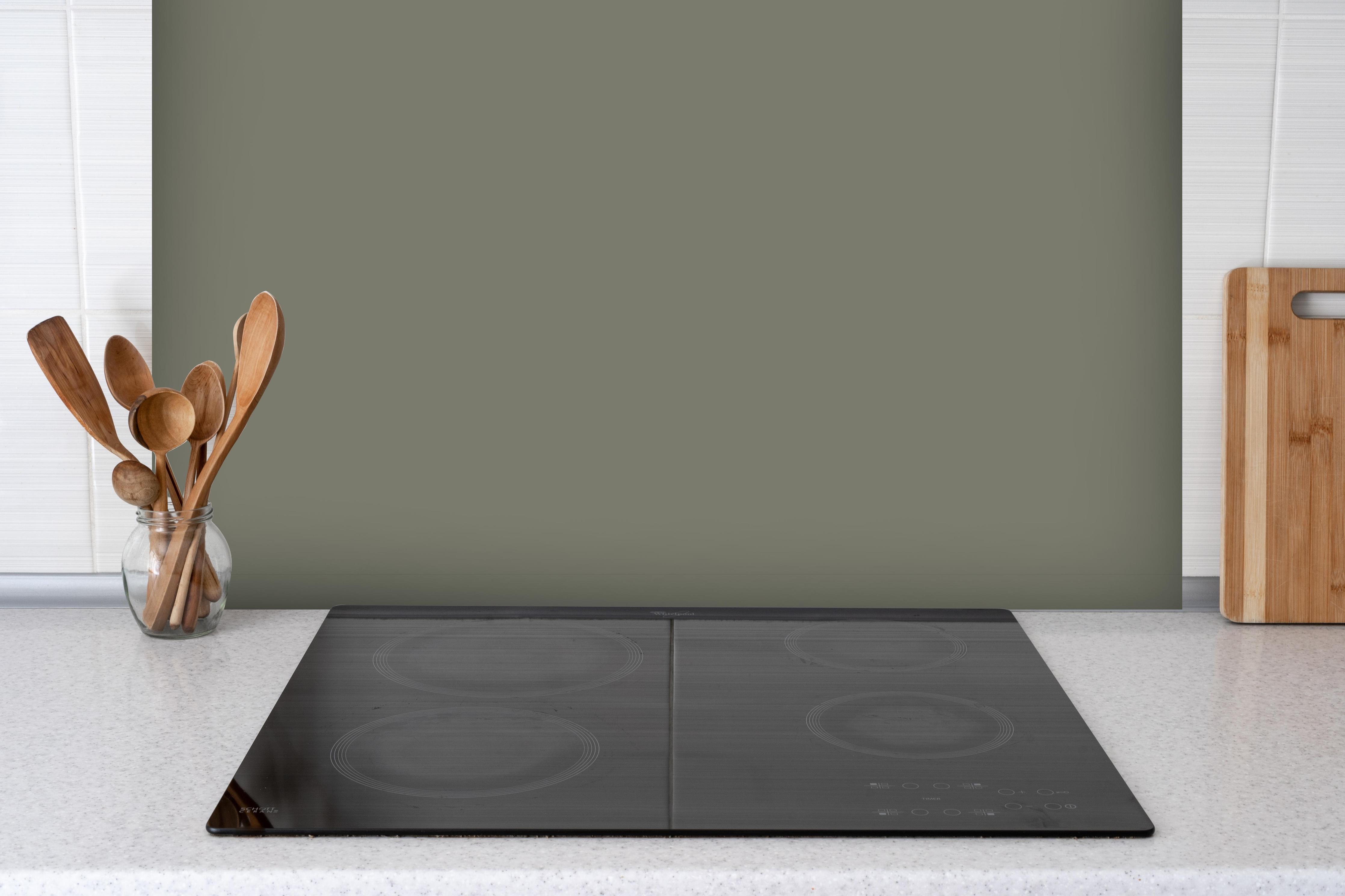Spritzschutz - RAL 7003 (Moosgrau) hinter einem Cerankochfeld zwischen Holz-Kochutensilien
