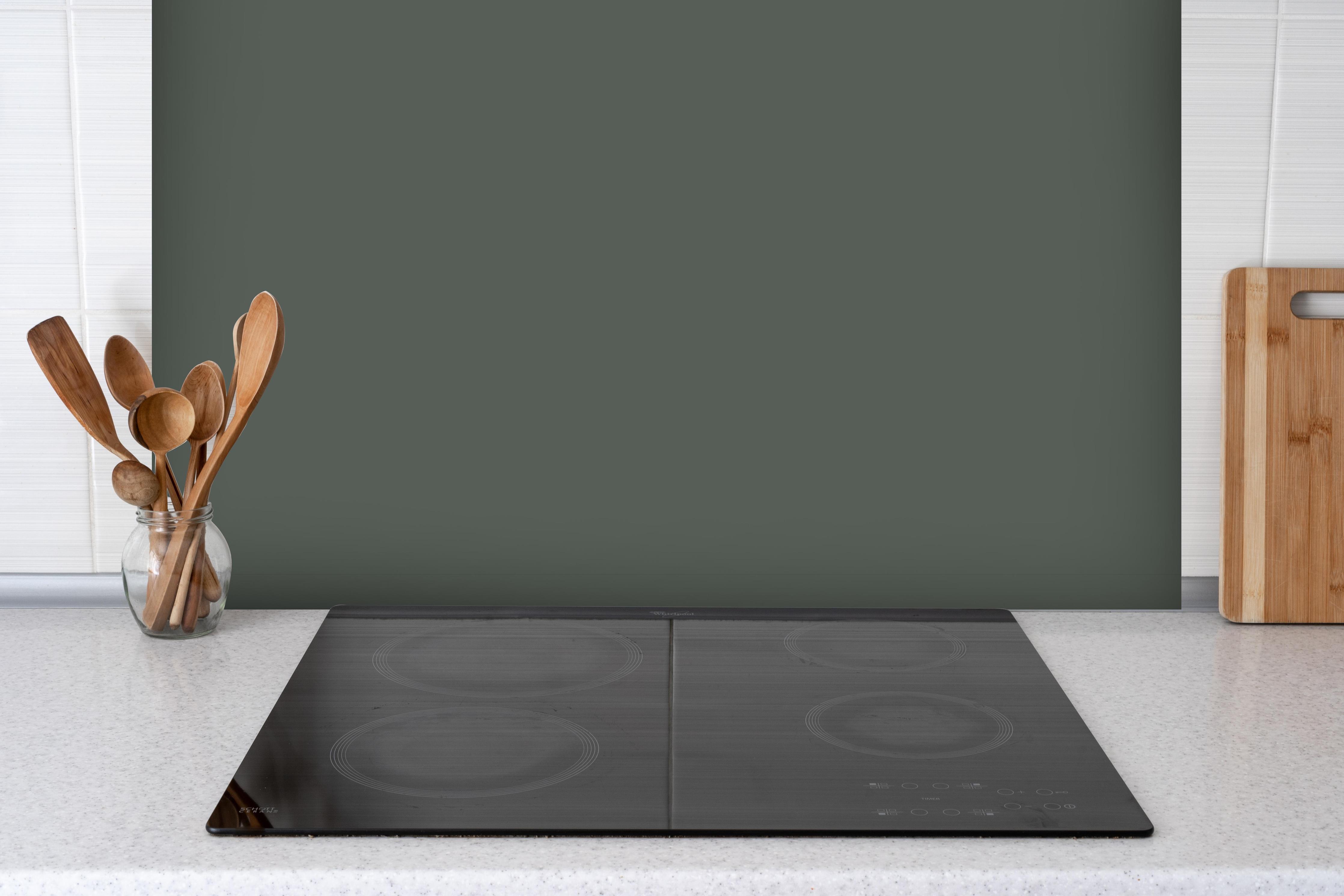 Spritzschutz - RAL 7010 (Plane grau) hinter einem Cerankochfeld zwischen Holz-Kochutensilien