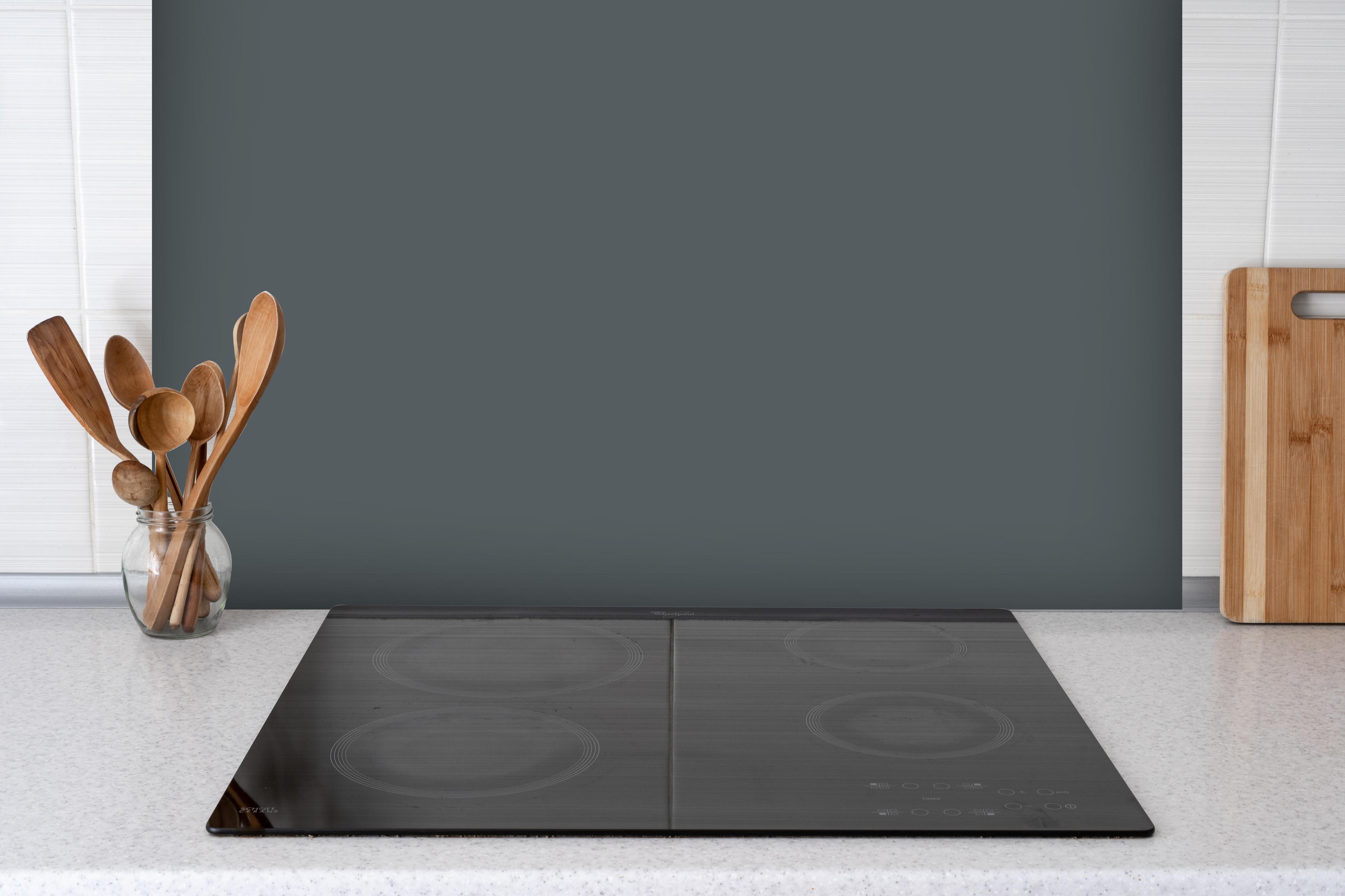 Spritzschutz - RAL 7011 (Eisengrau) hinter einem Cerankochfeld zwischen Holz-Kochutensilien