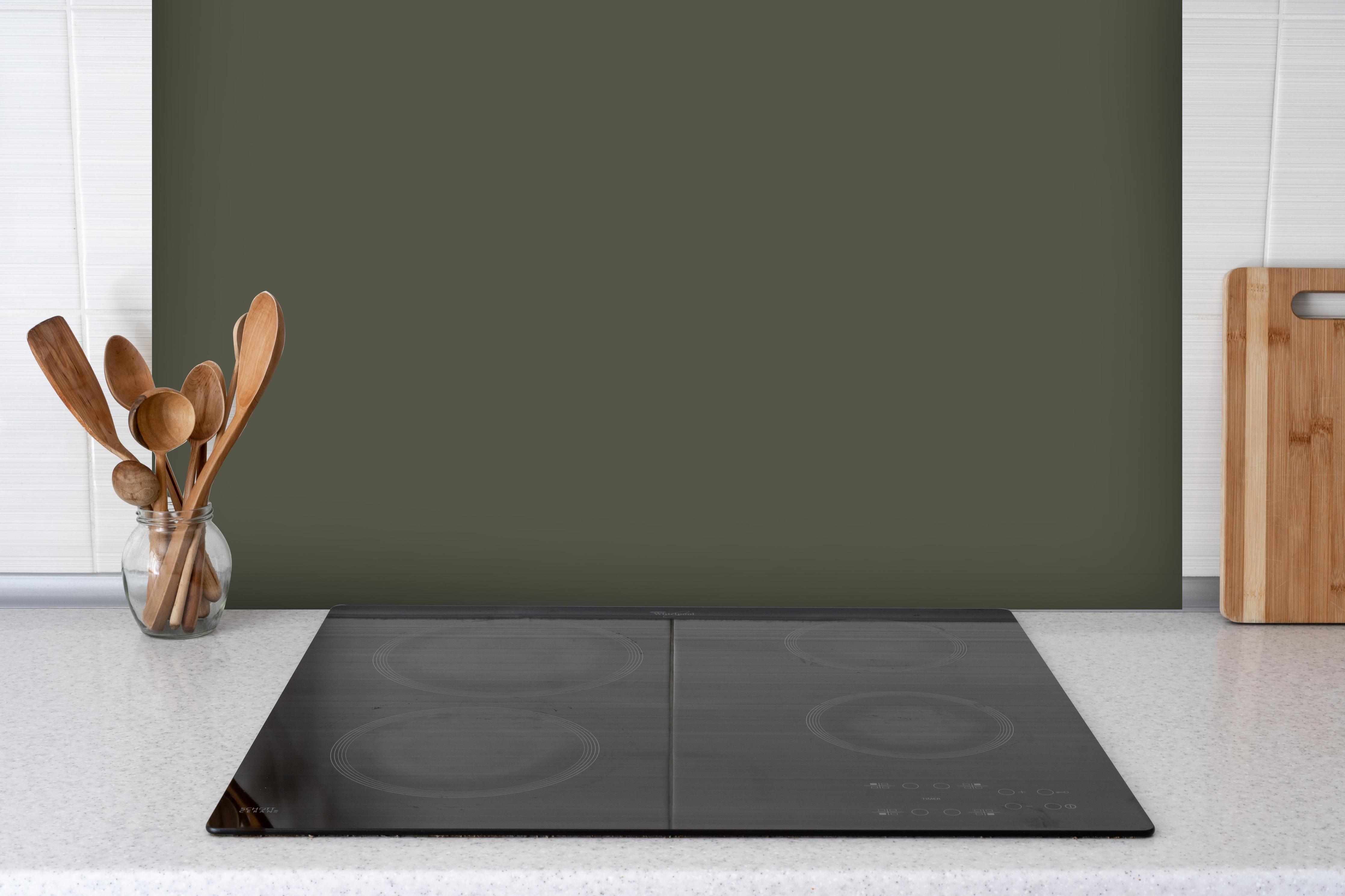 Spritzschutz - RAL 7013 (auch braun-grau) hinter einem Cerankochfeld zwischen Holz-Kochutensilien