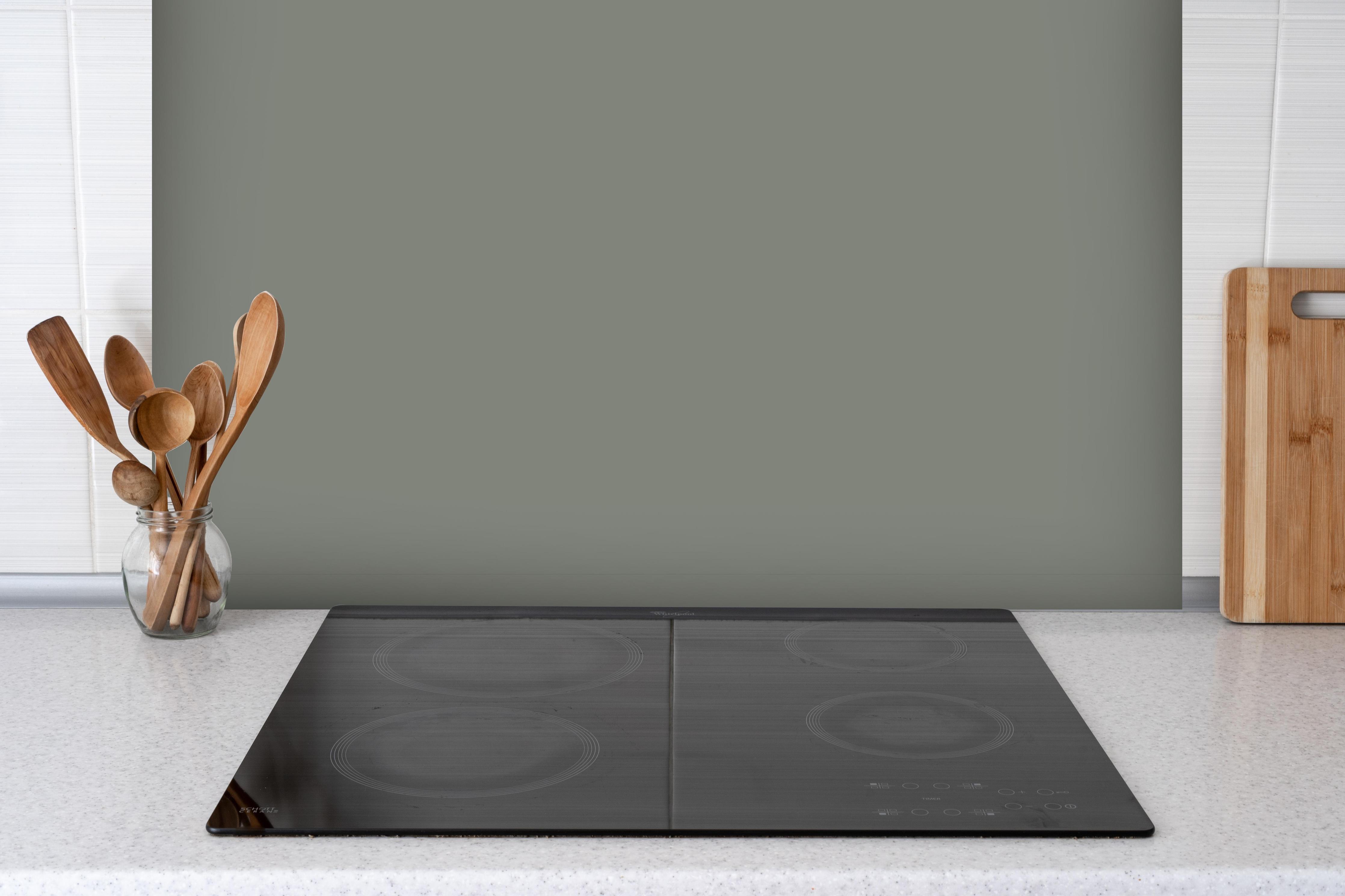 Spritzschutz - RAL 7023 (Betongrau) hinter einem Cerankochfeld zwischen Holz-Kochutensilien