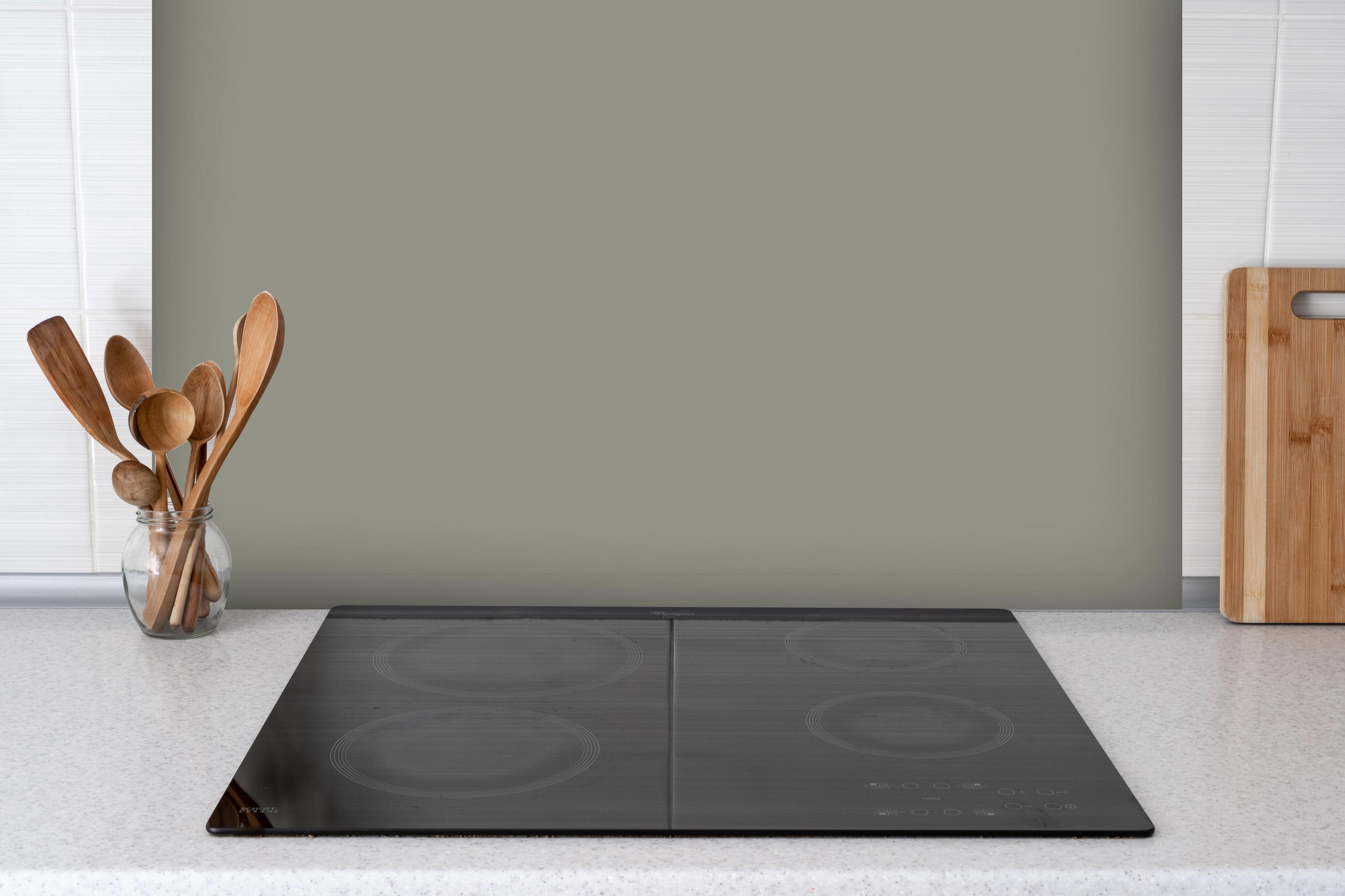 Spritzschutz - RAL 7030 (Steingrau) hinter einem Cerankochfeld zwischen Holz-Kochutensilien