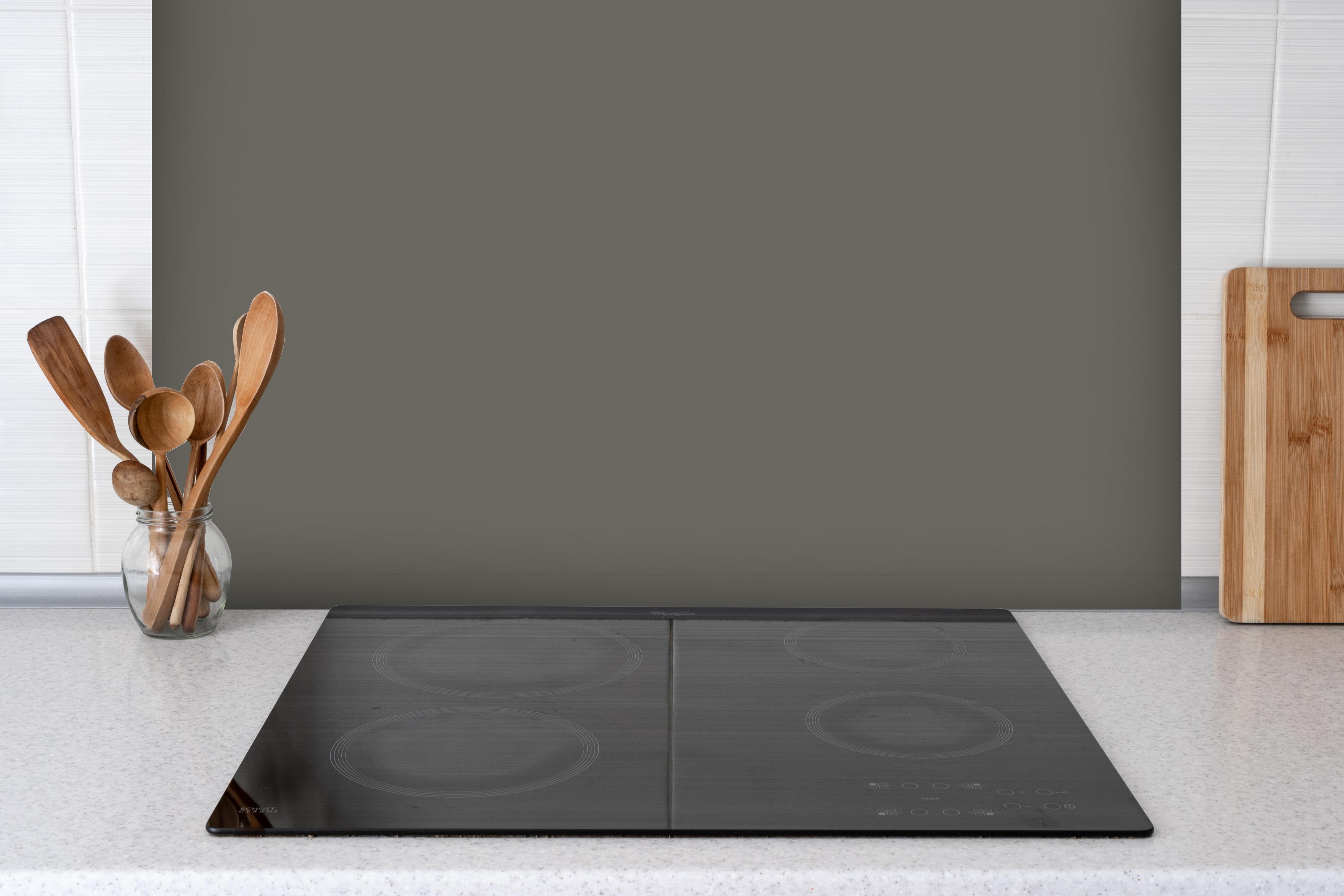 Spritzschutz - RAL 7039 (Quarzgrau) hinter einem Cerankochfeld zwischen Holz-Kochutensilien