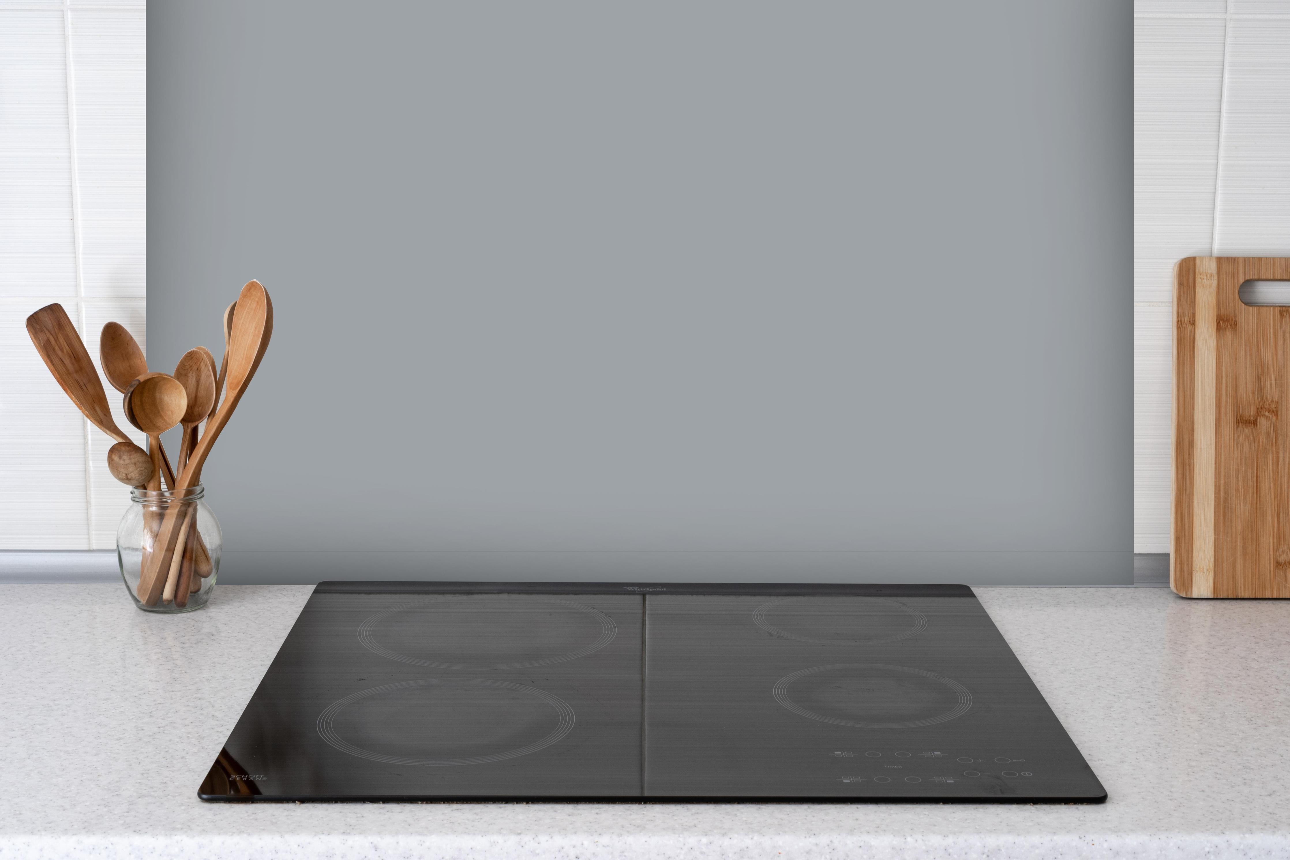 Spritzschutz - RAL 7040 (Fenstergrau) hinter einem Cerankochfeld zwischen Holz-Kochutensilien