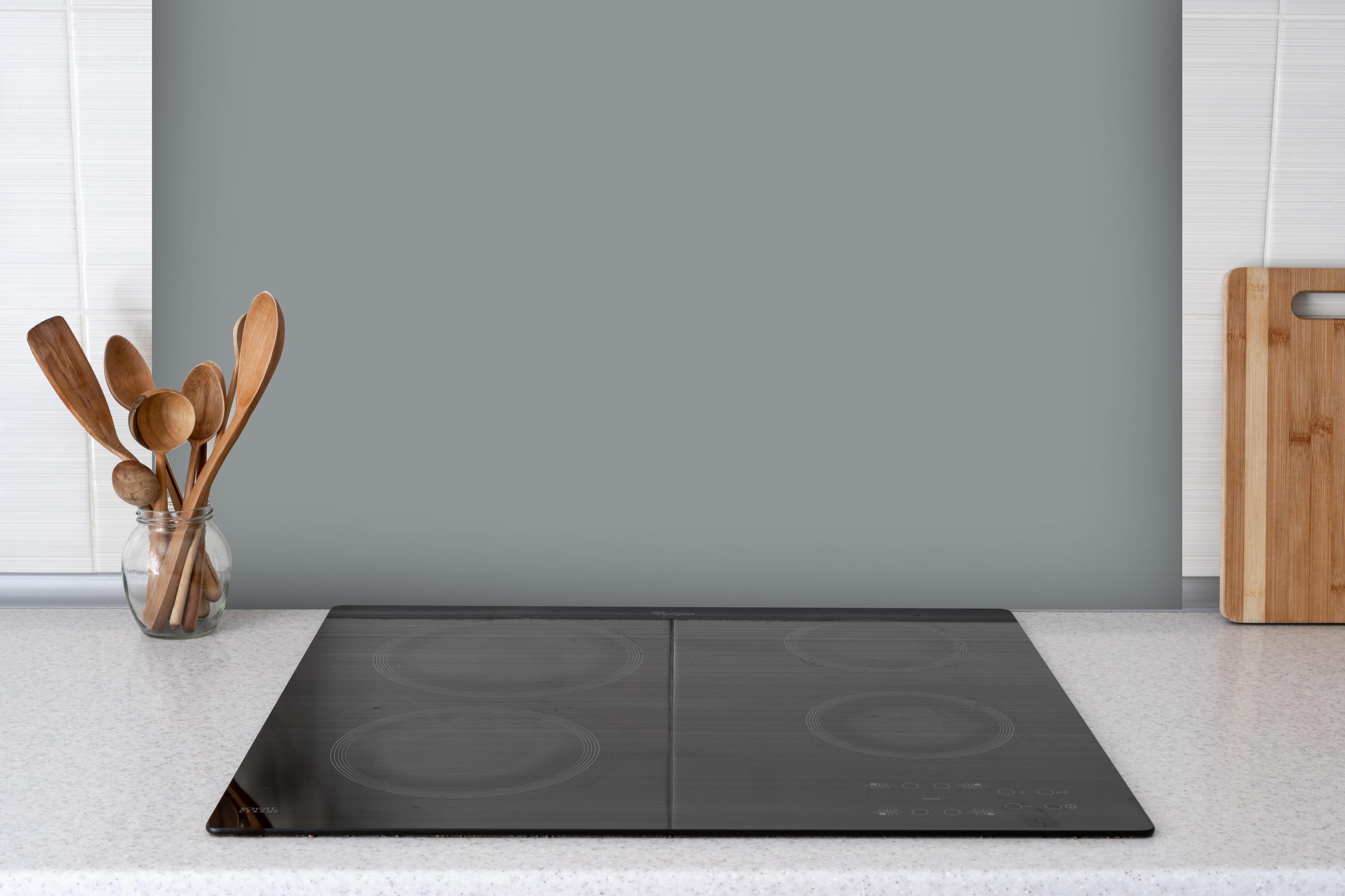 Spritzschutz - RAL 7042 (Verkehrsgrau A) hinter einem Cerankochfeld zwischen Holz-Kochutensilien